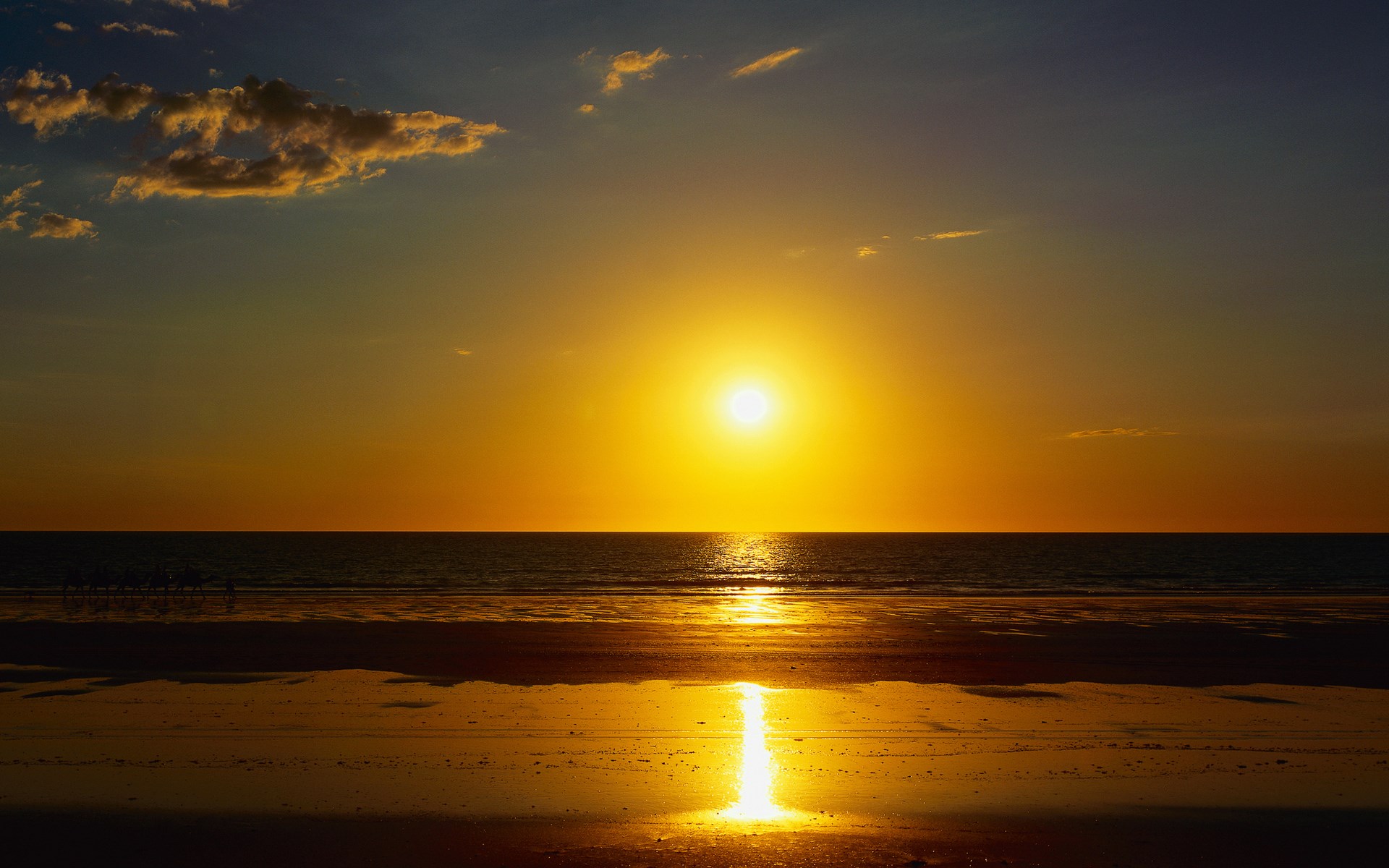 Sunset over the ocean with a beach in the foreground HD Wallpaper