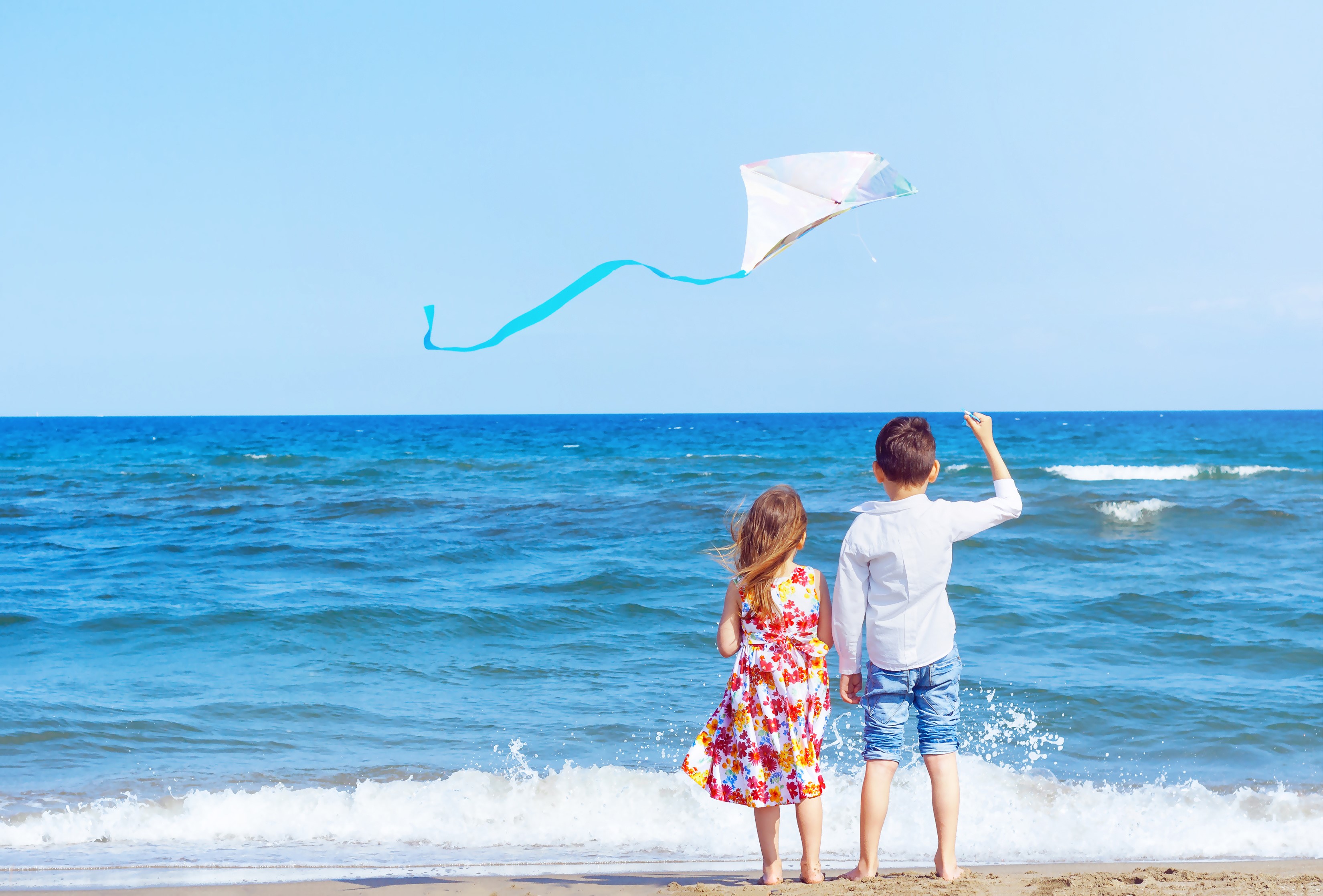 Children flying a kite on the beach HD Wallpaper