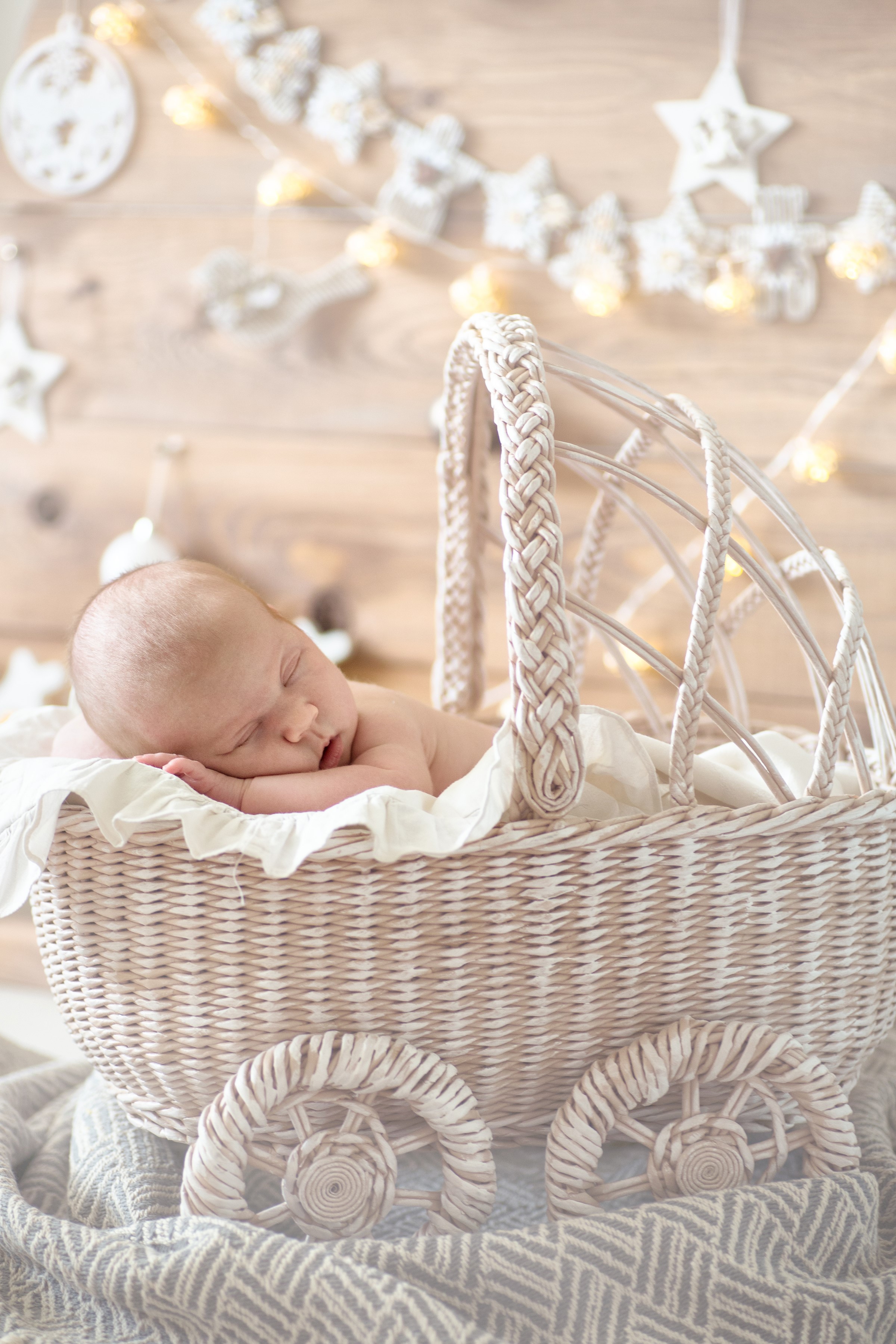 Baby sleeping in a wicker basket with Christmas lights HD Phone Wallpaper