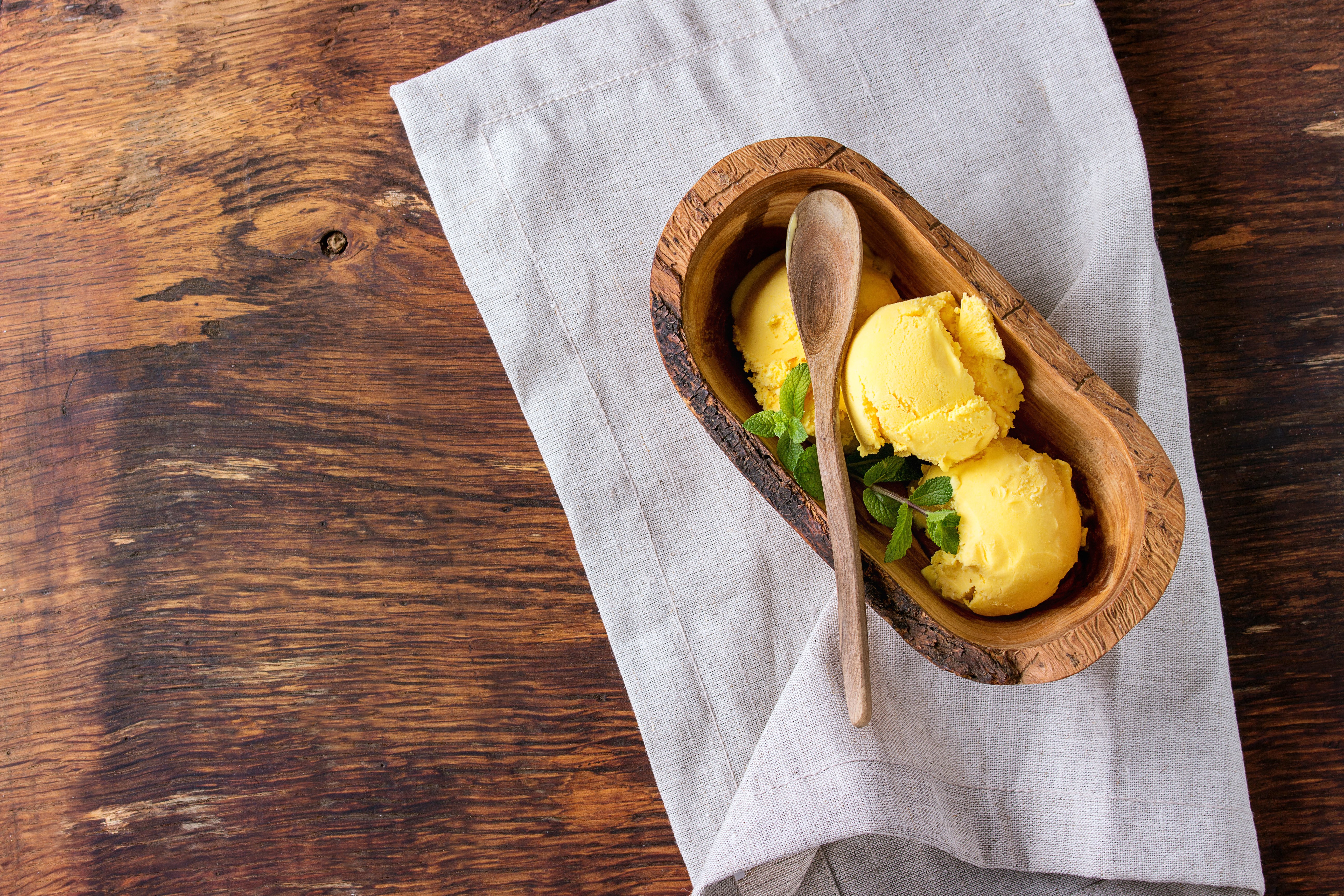 Yellow ice cream scoops in a wooden bowl HD Wallpaper