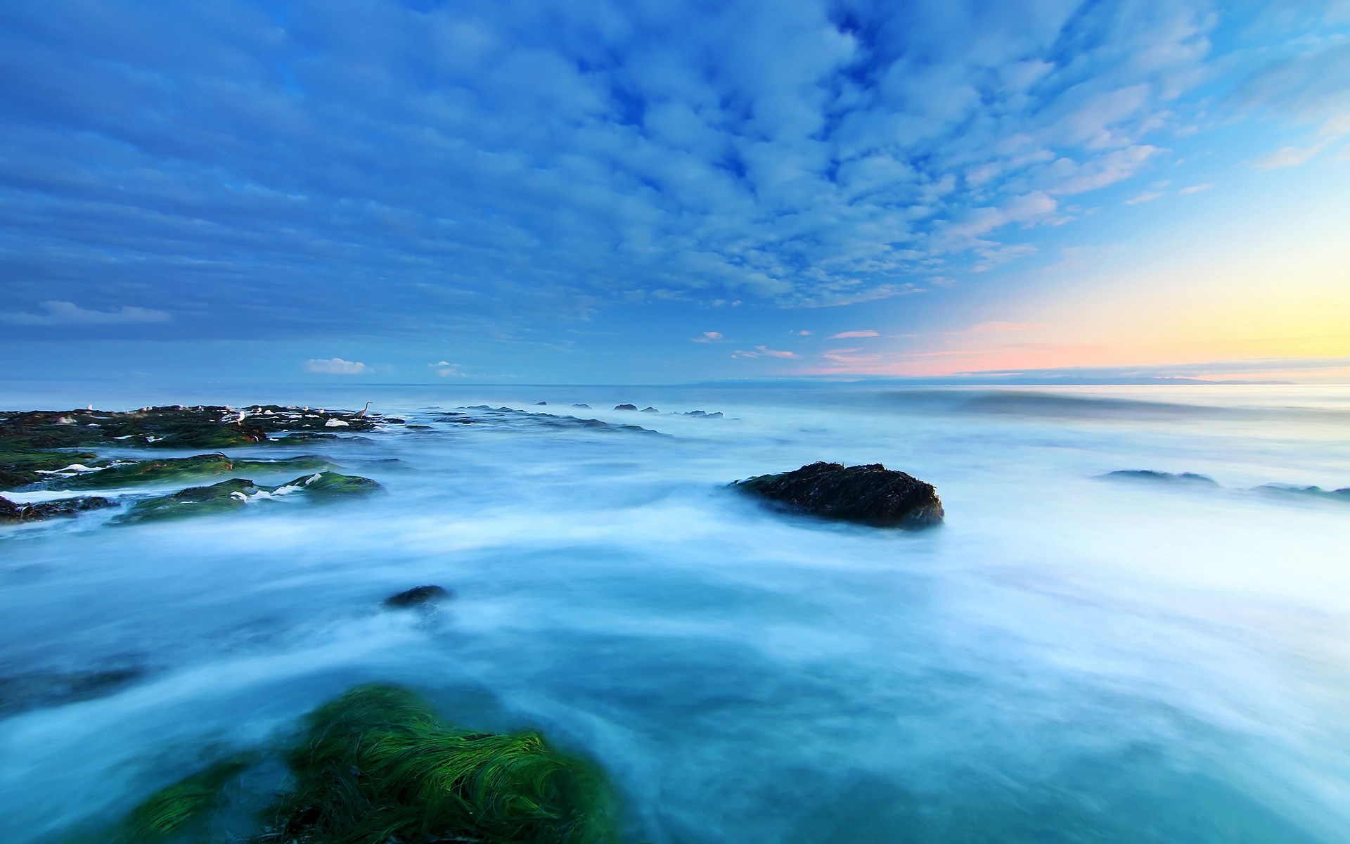 Ocean waves crashing on rocky shore at sunset HD Wallpaper