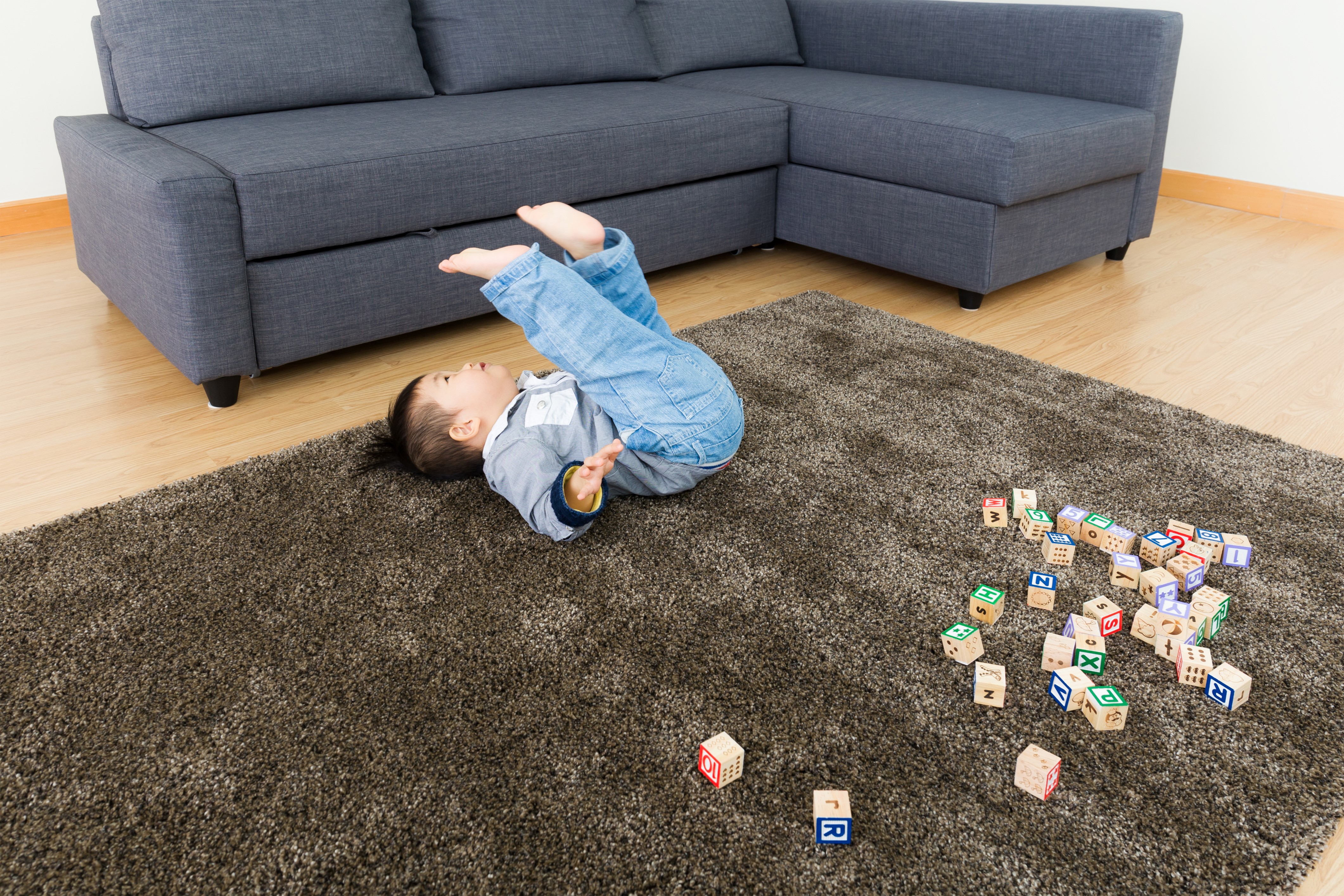 Boy playing with alphabet blocks on a carpet HD Wallpaper