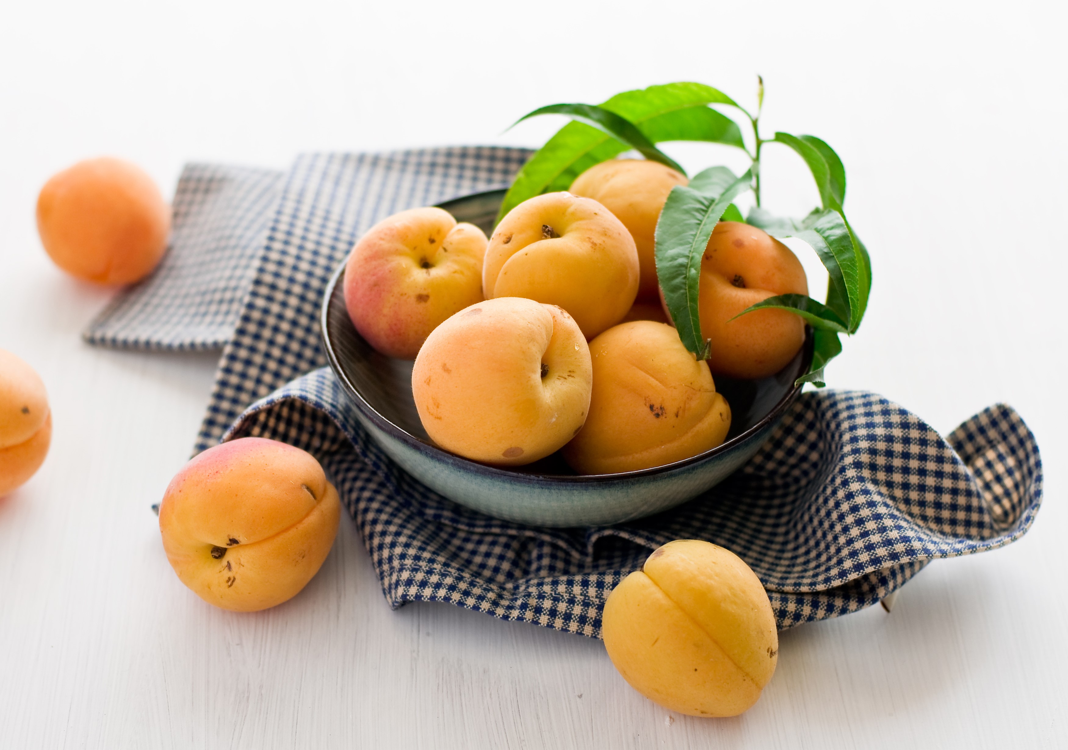 Apricots in a bowl with leaves HD Wallpaper