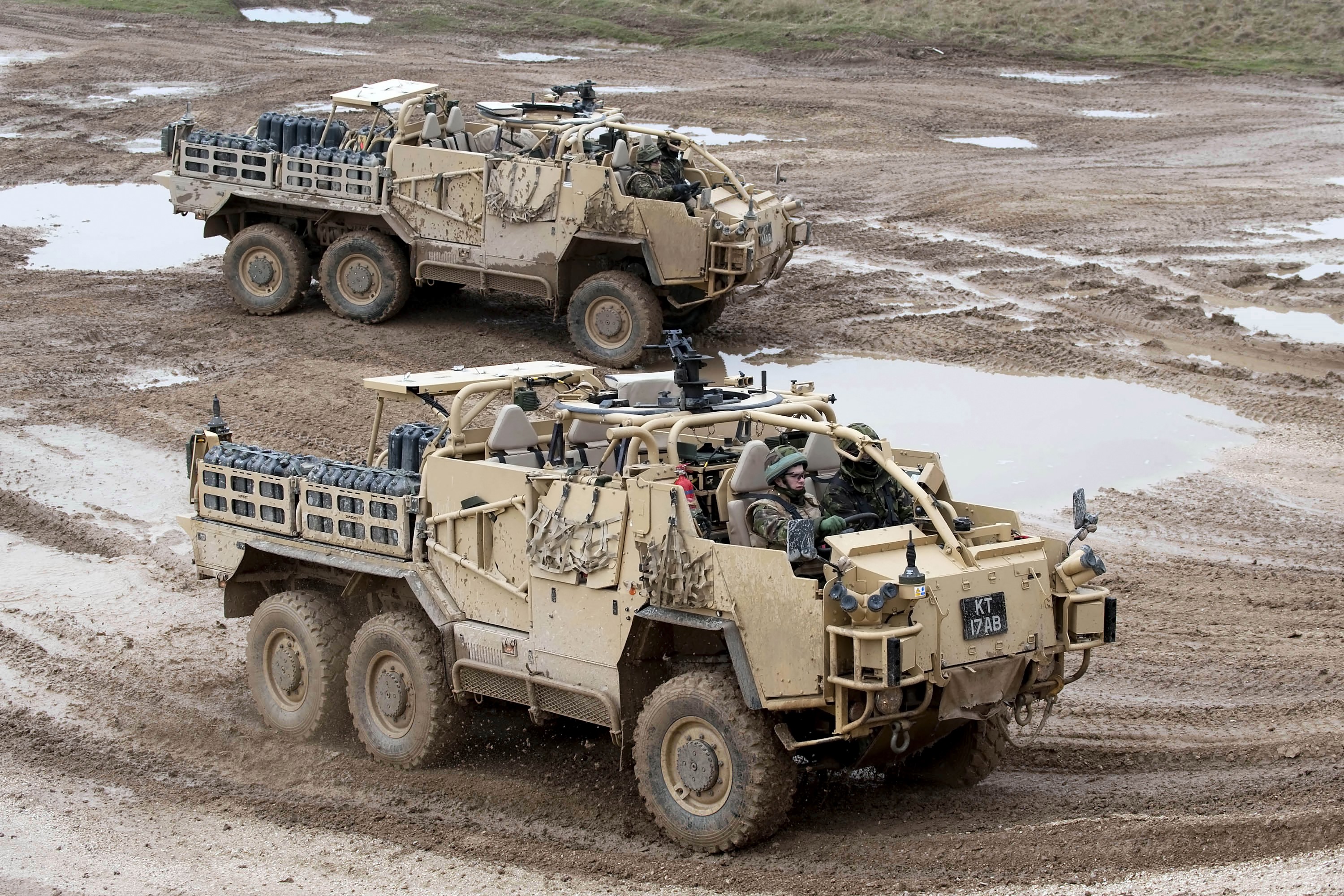 Two Coyote TSV military vehicles in muddy terrain HD Wallpaper