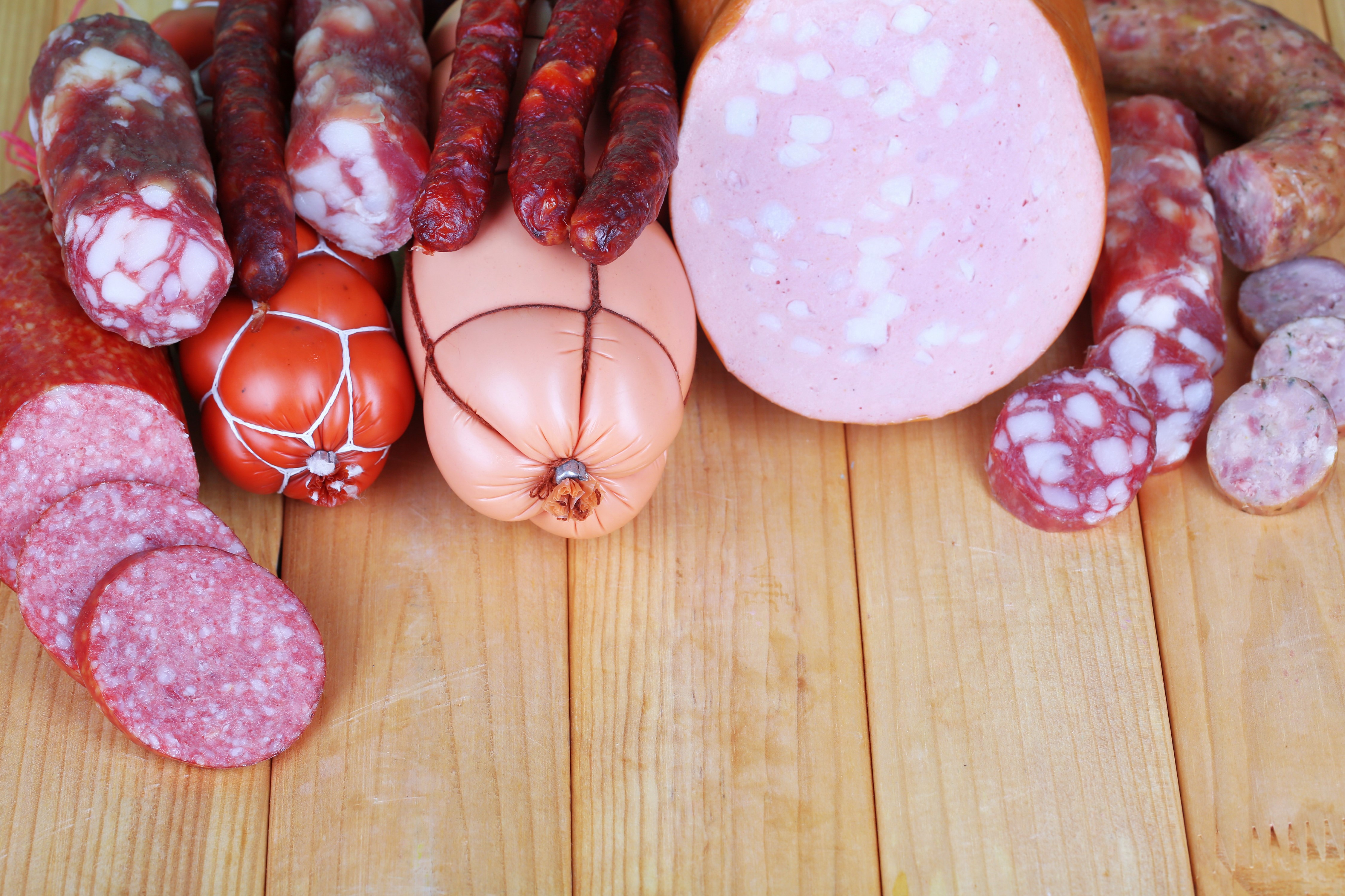 Assortment of sausages on wooden planks HD Wallpaper