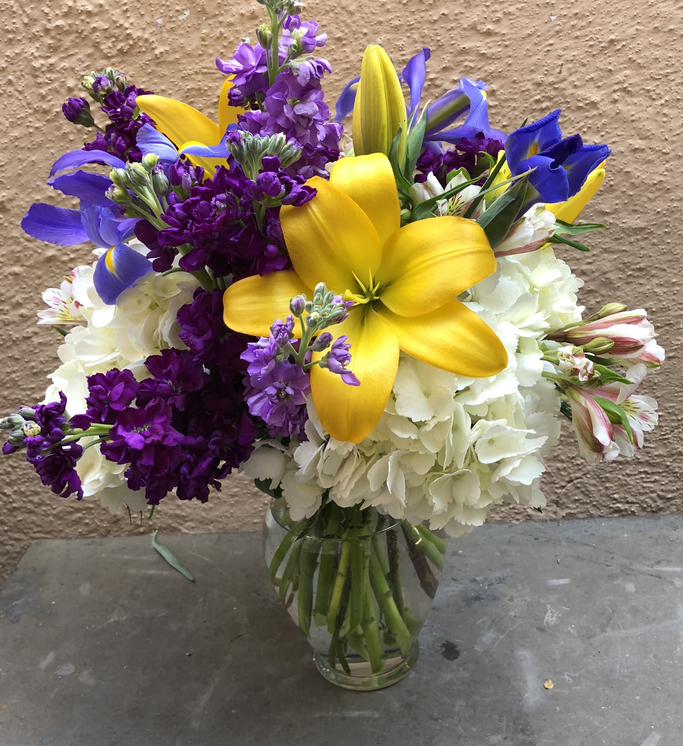 Yellow lilies, purple stock, white hydrangea, and blue irises in a vase HD Wallpaper