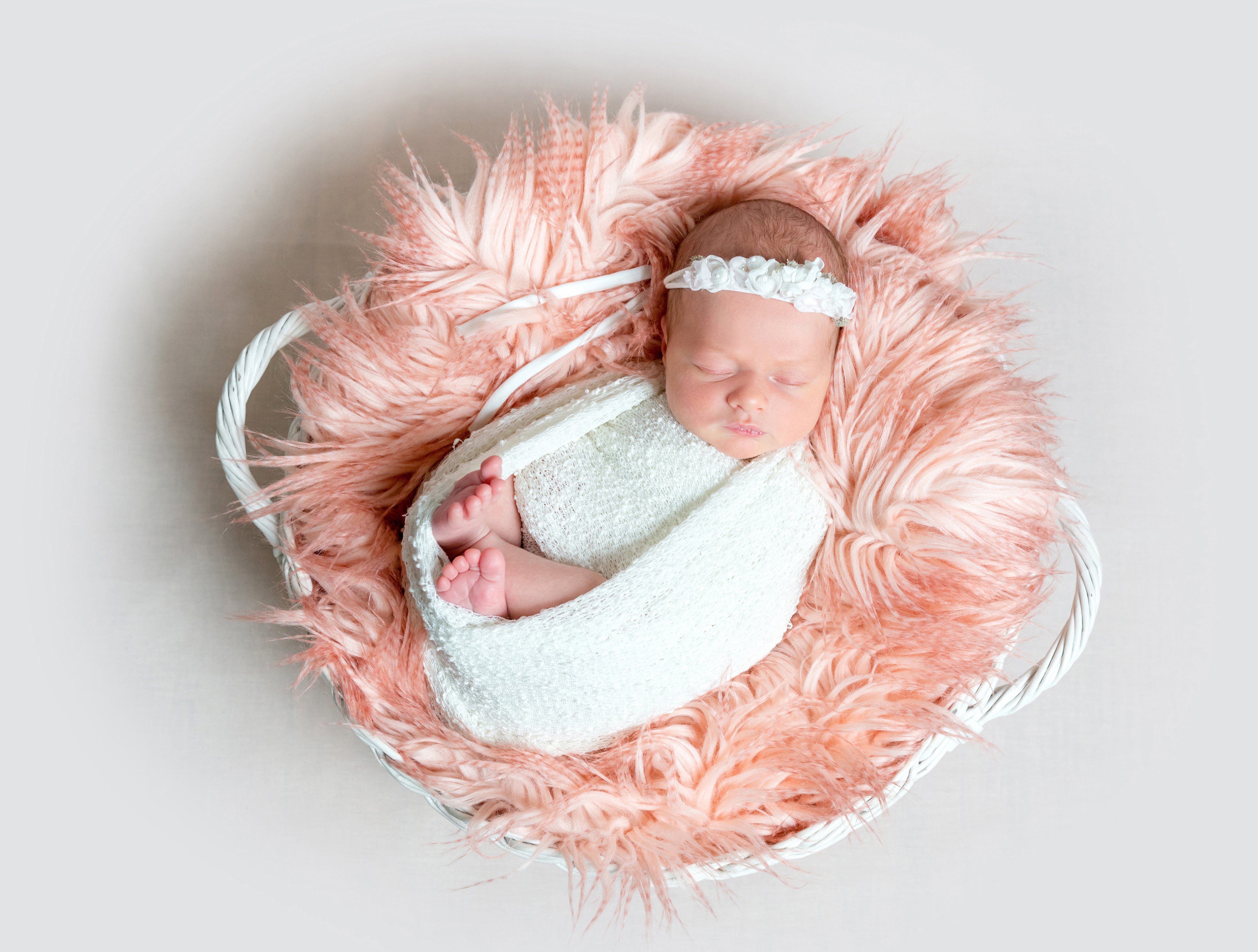 Newborn baby sleeping in a basket HD Wallpaper