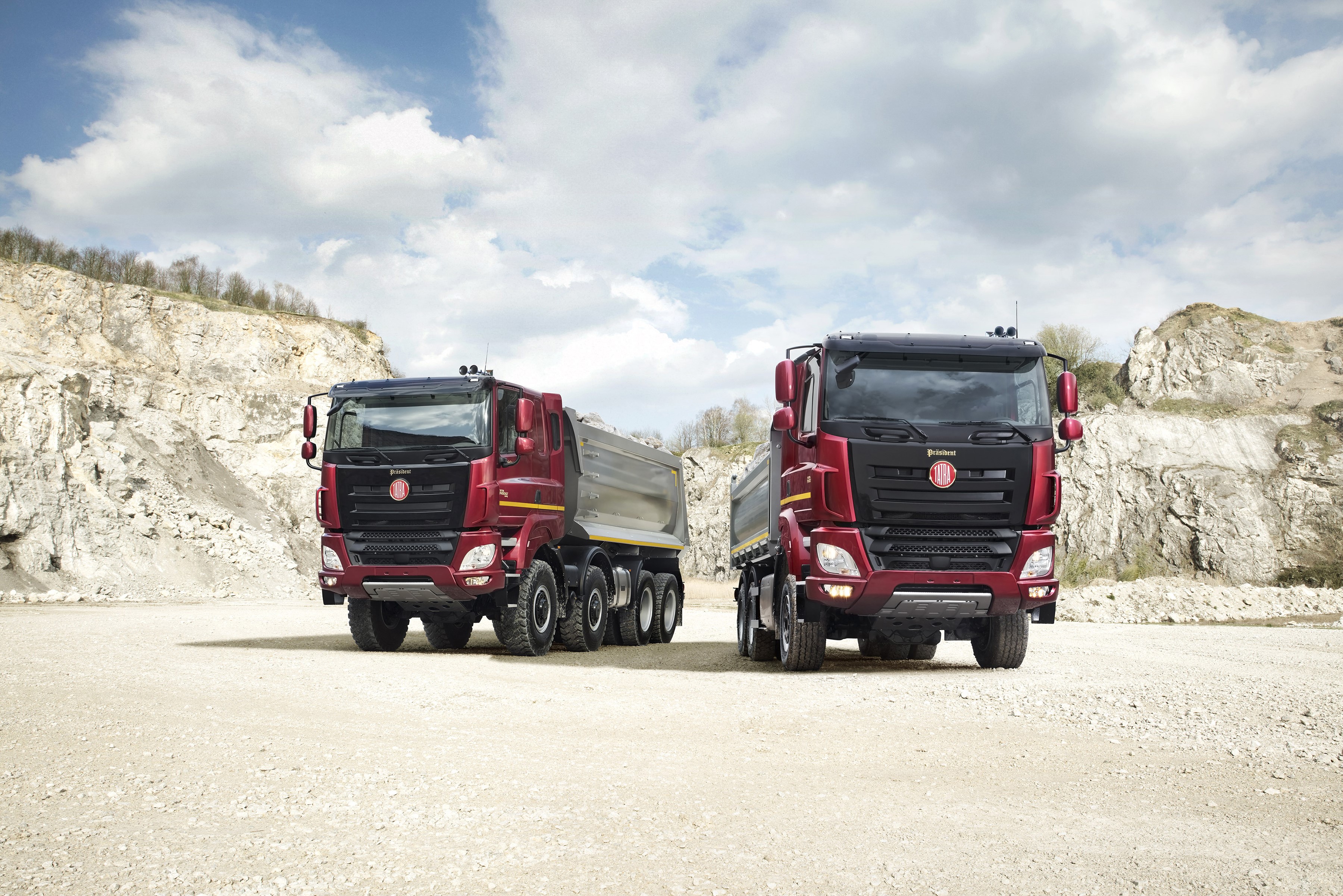 Two red Tatra dump trucks in a quarry HD Wallpaper
