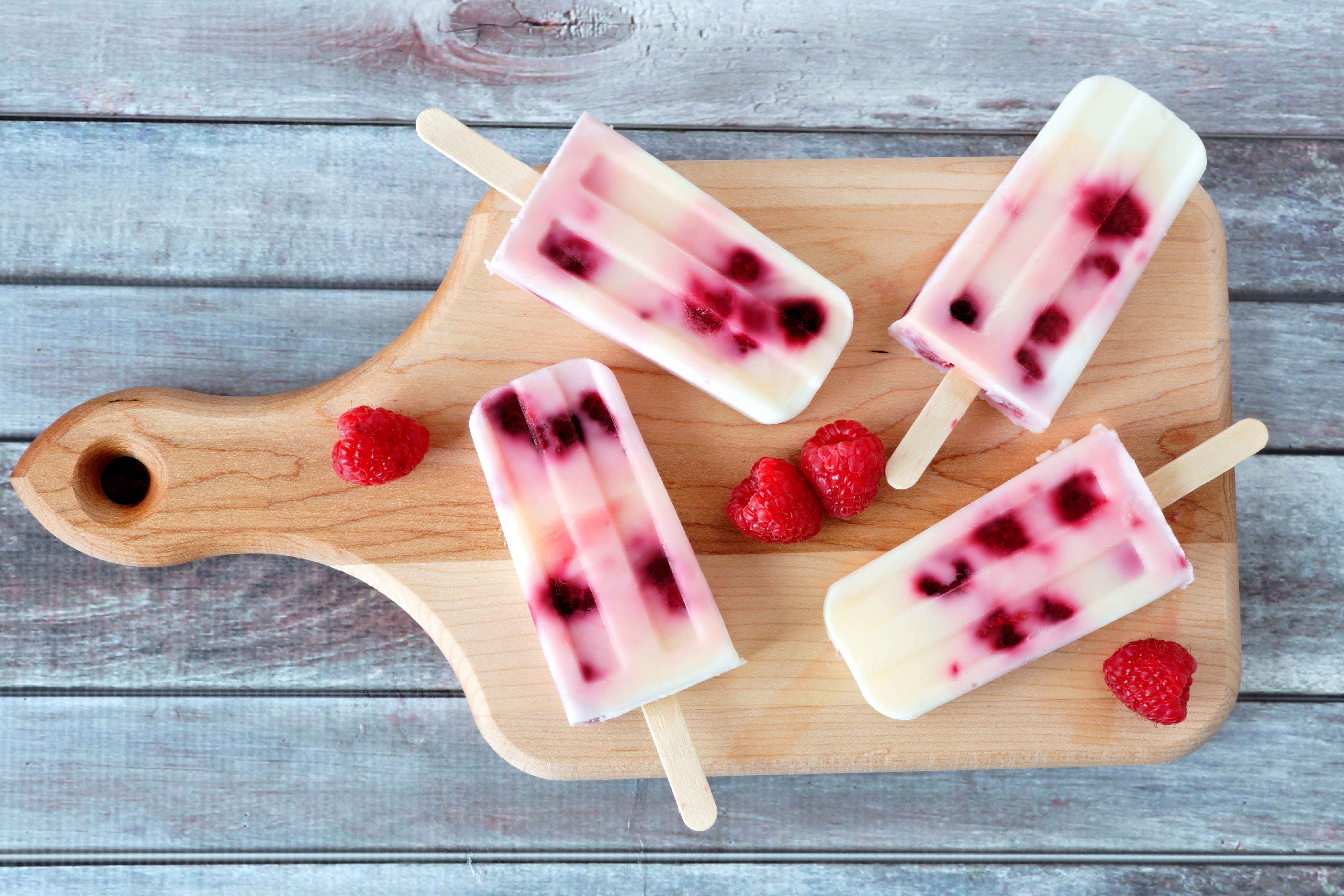 Raspberry popsicles on a wooden cutting board HD Wallpaper