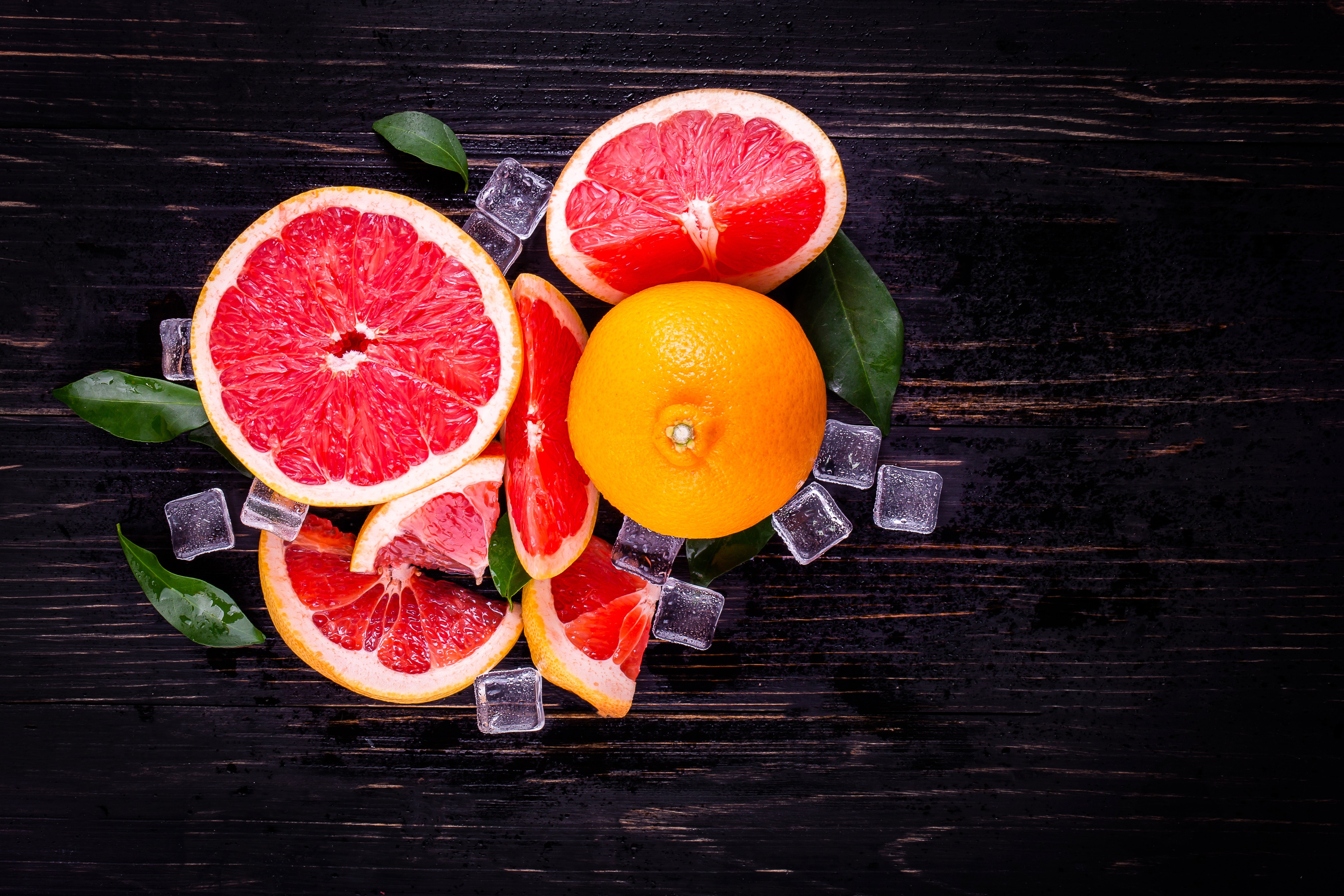 Grapefruit slices and whole grapefruit with ice cubes HD Wallpaper