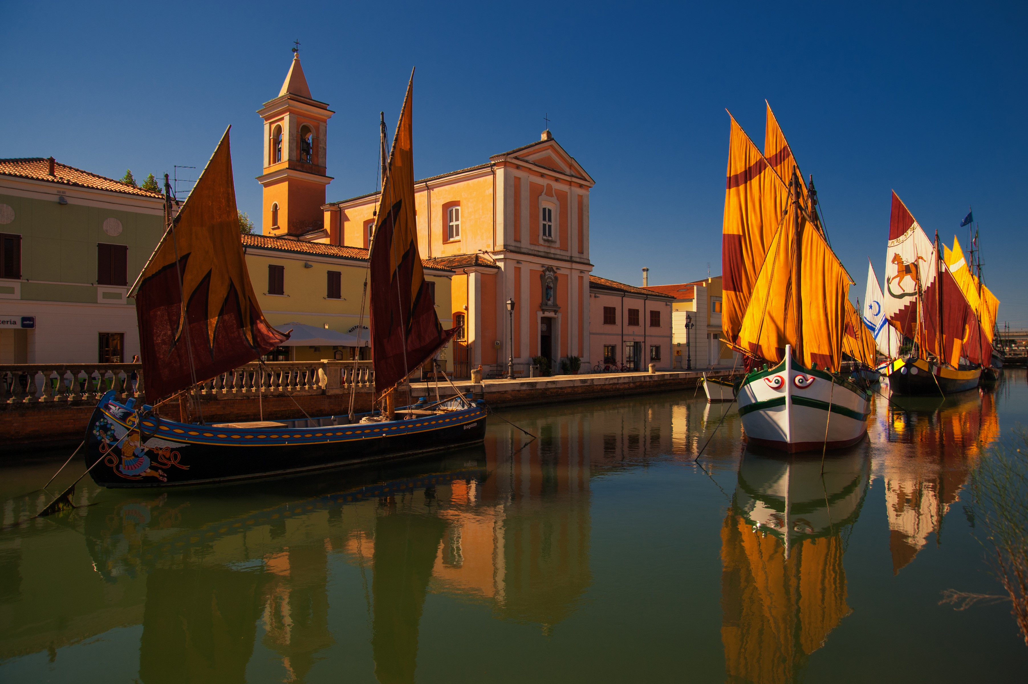 Traditional boats in Cesenatico canal with church HD Wallpaper
