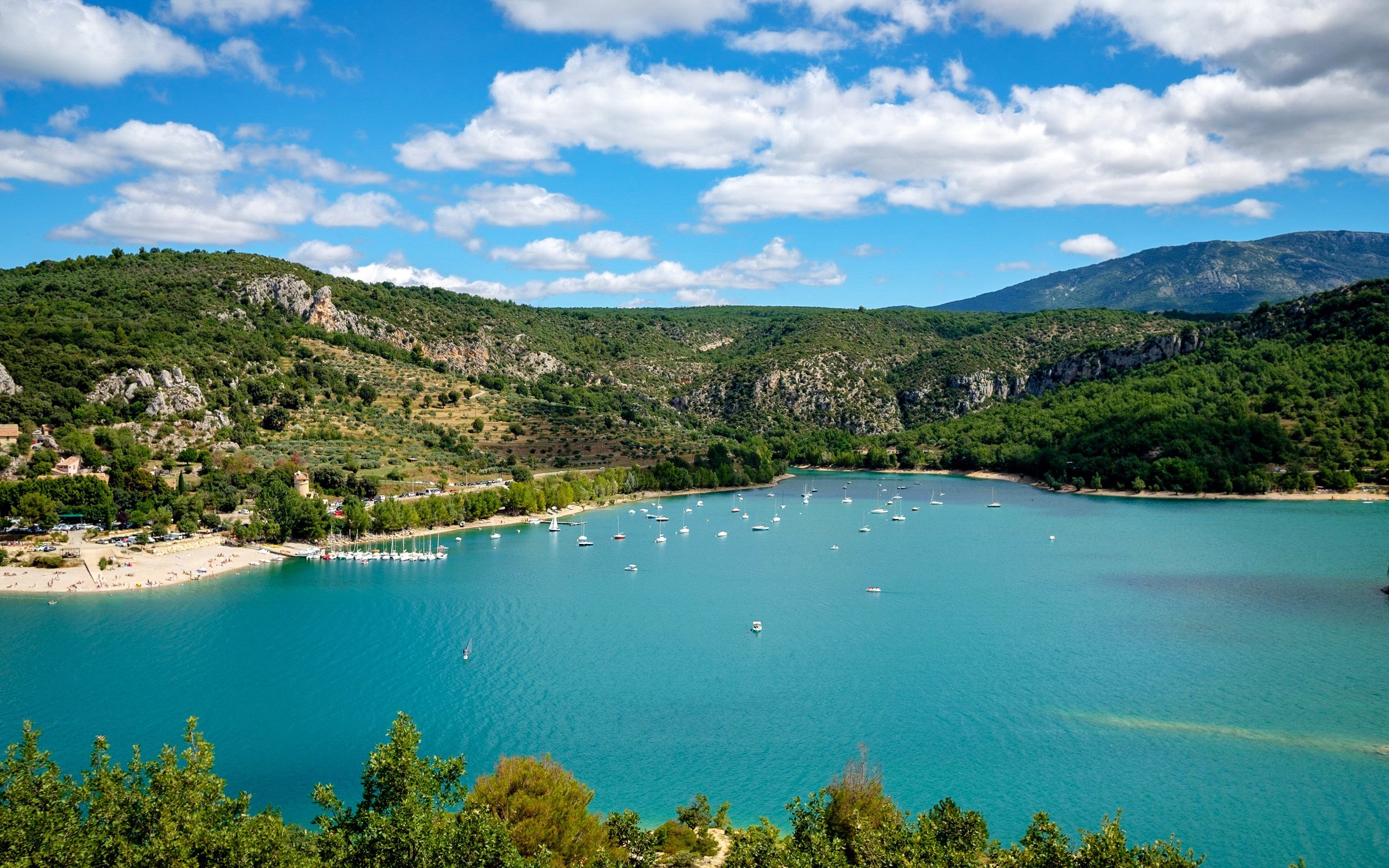 Boats on a turquoise lake surrounded by green hills in France HD Wallpaper