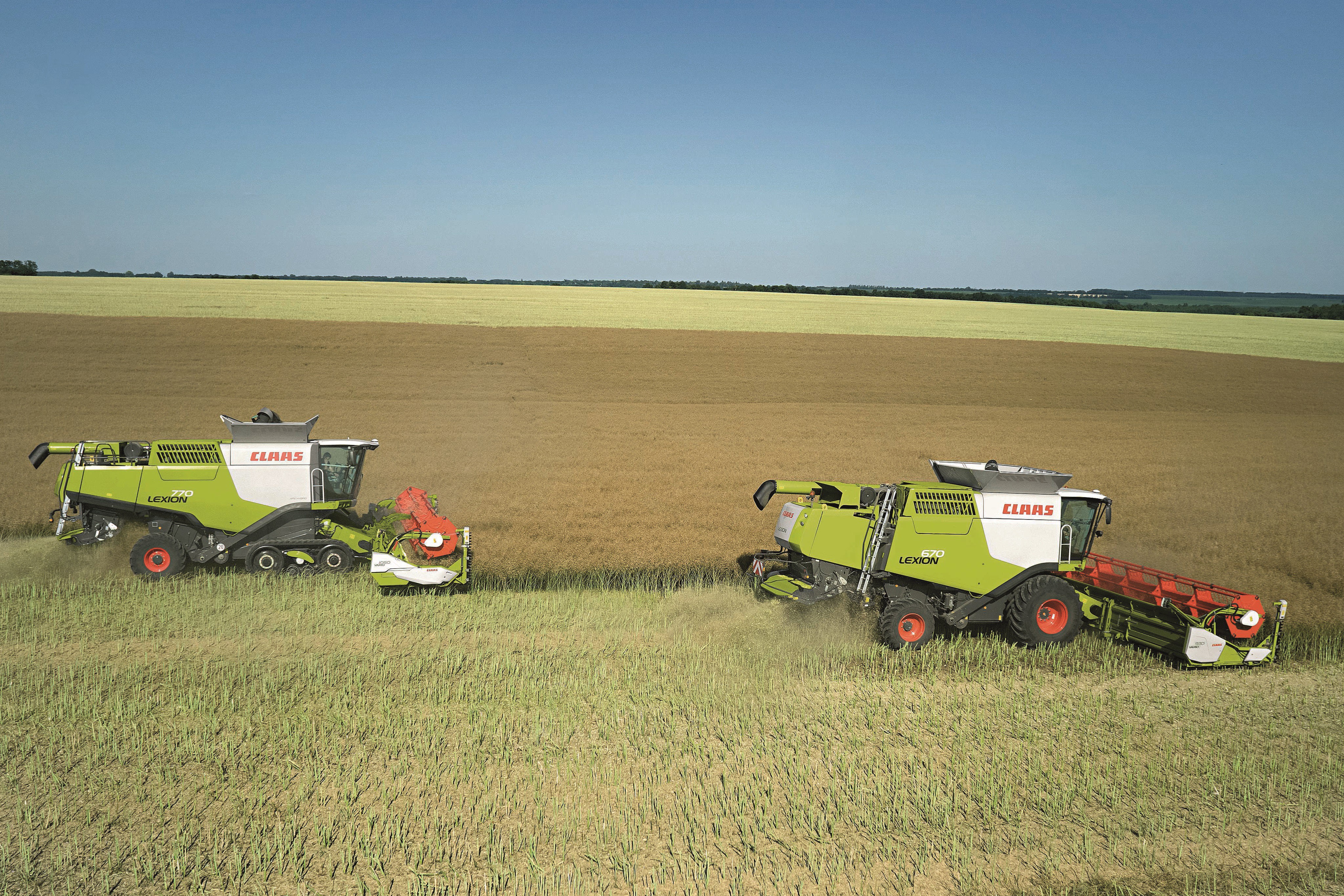 Two Claas Lexion combine harvesters in a field HD Wallpaper
