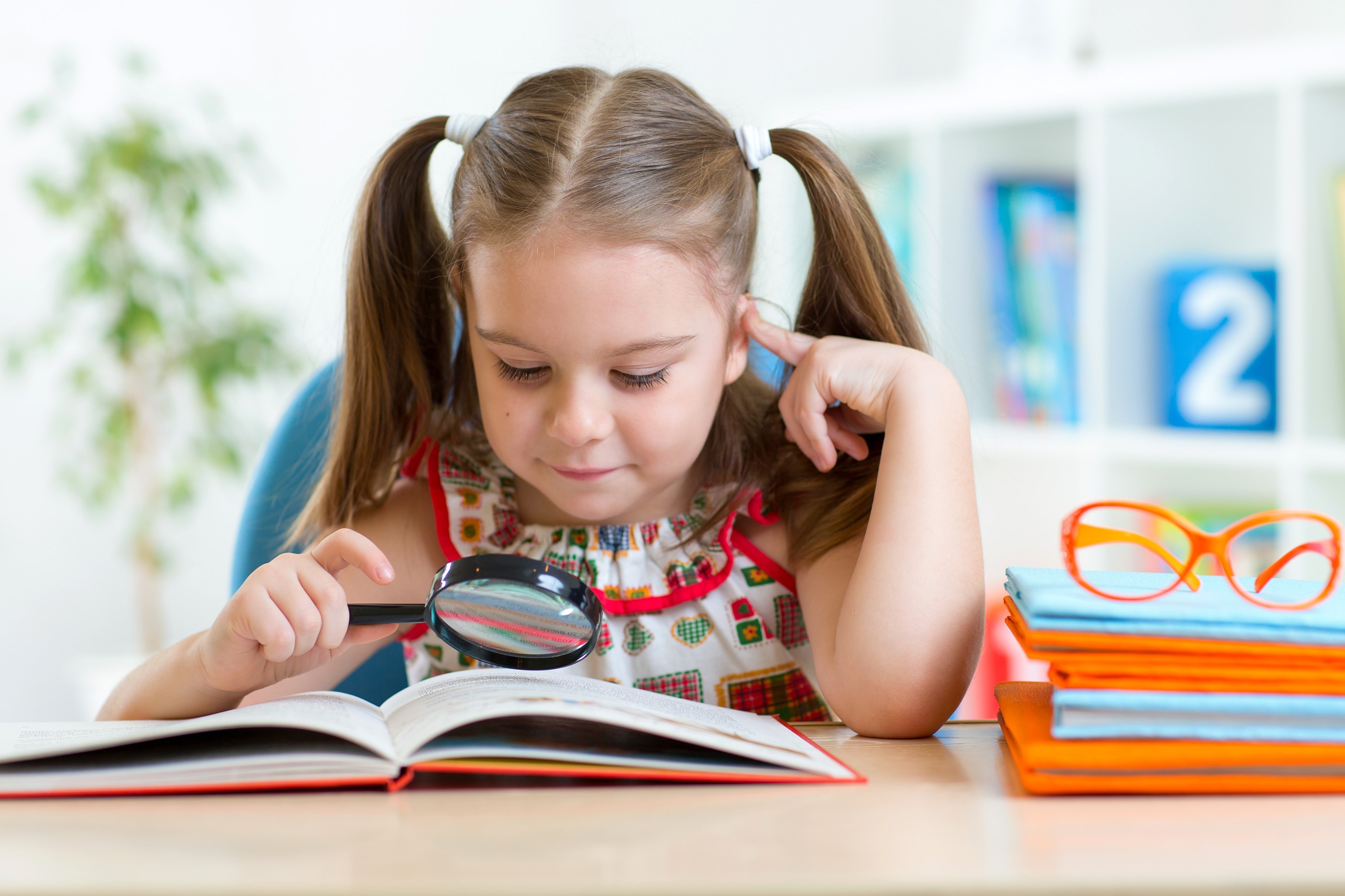Girl with magnifying glass reading a book HD Wallpaper