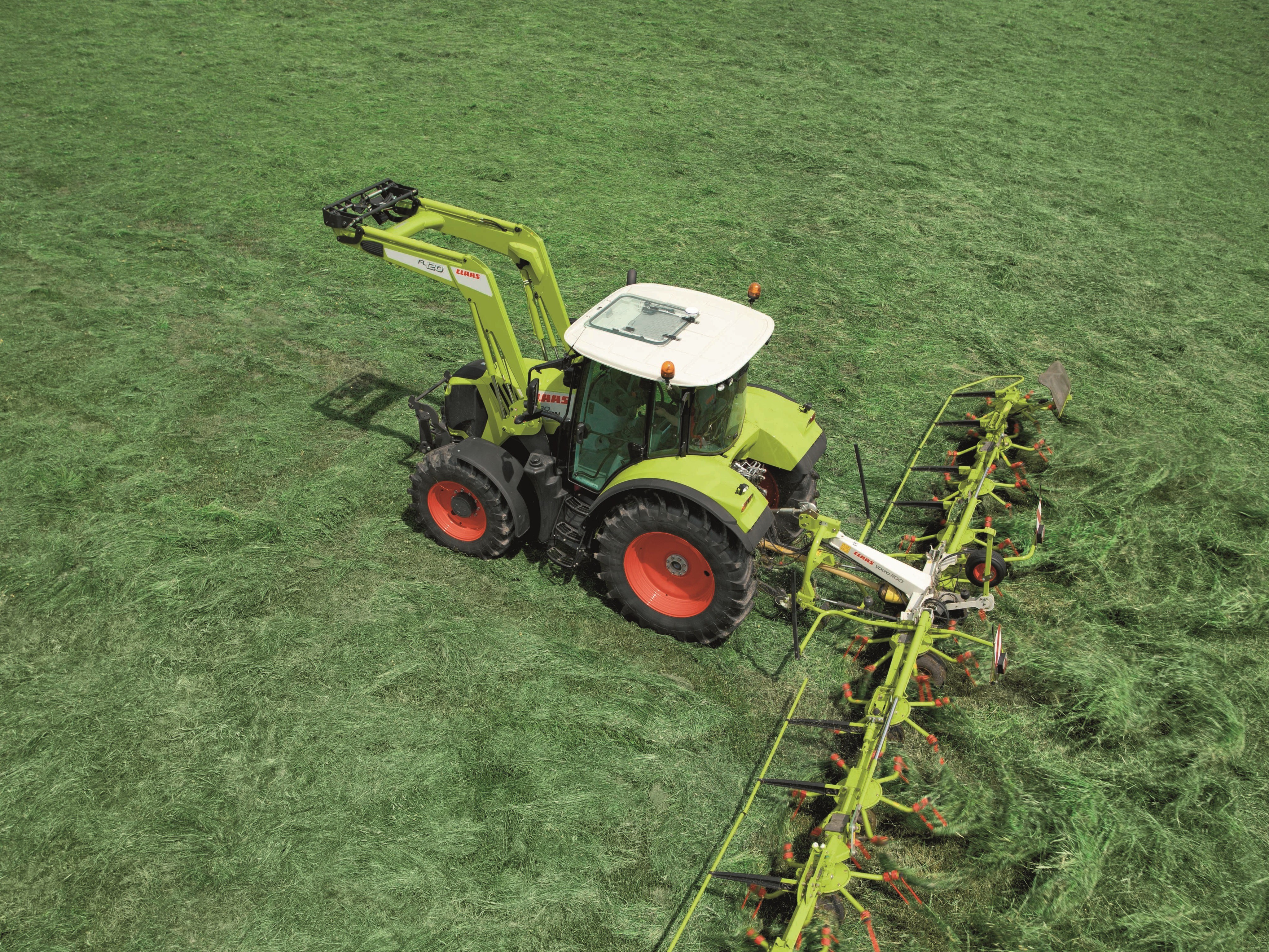 Claas Arion tractor with hay rake in field HD Wallpaper