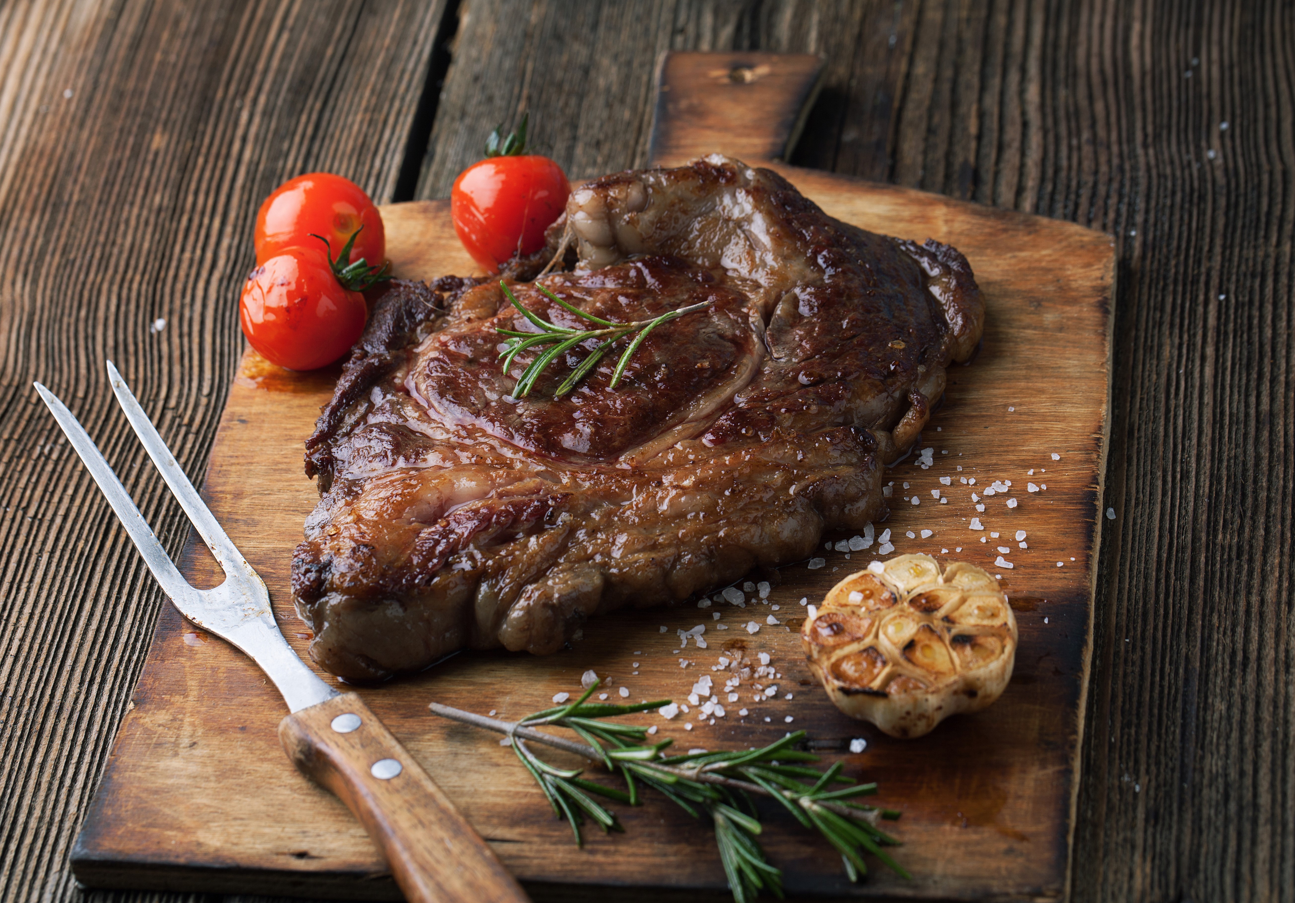 Steak with Tomatoes and Garlic on Cutting Board HD Wallpaper