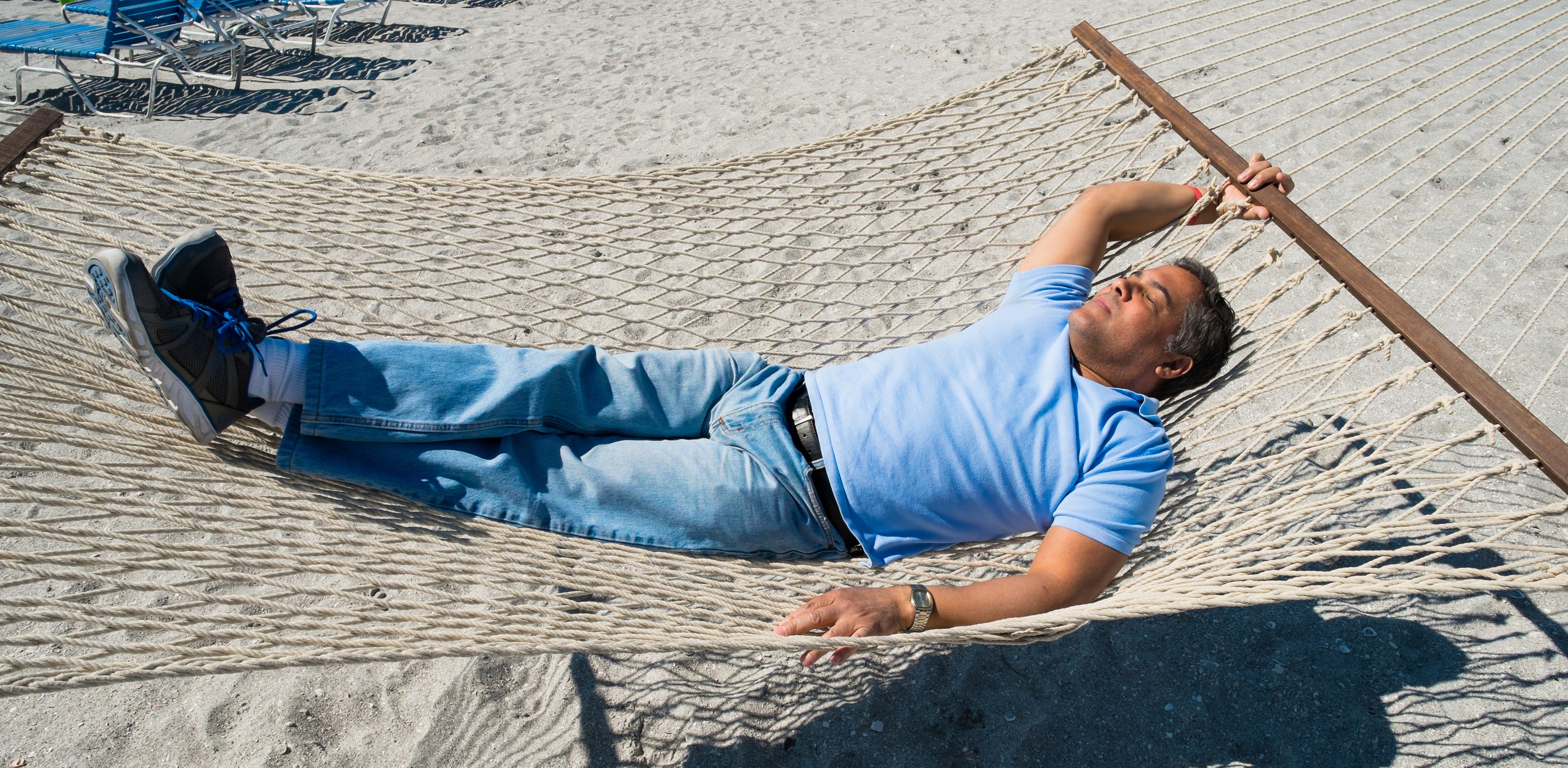 Man sleeping in a hammock on the beach HD Wallpaper