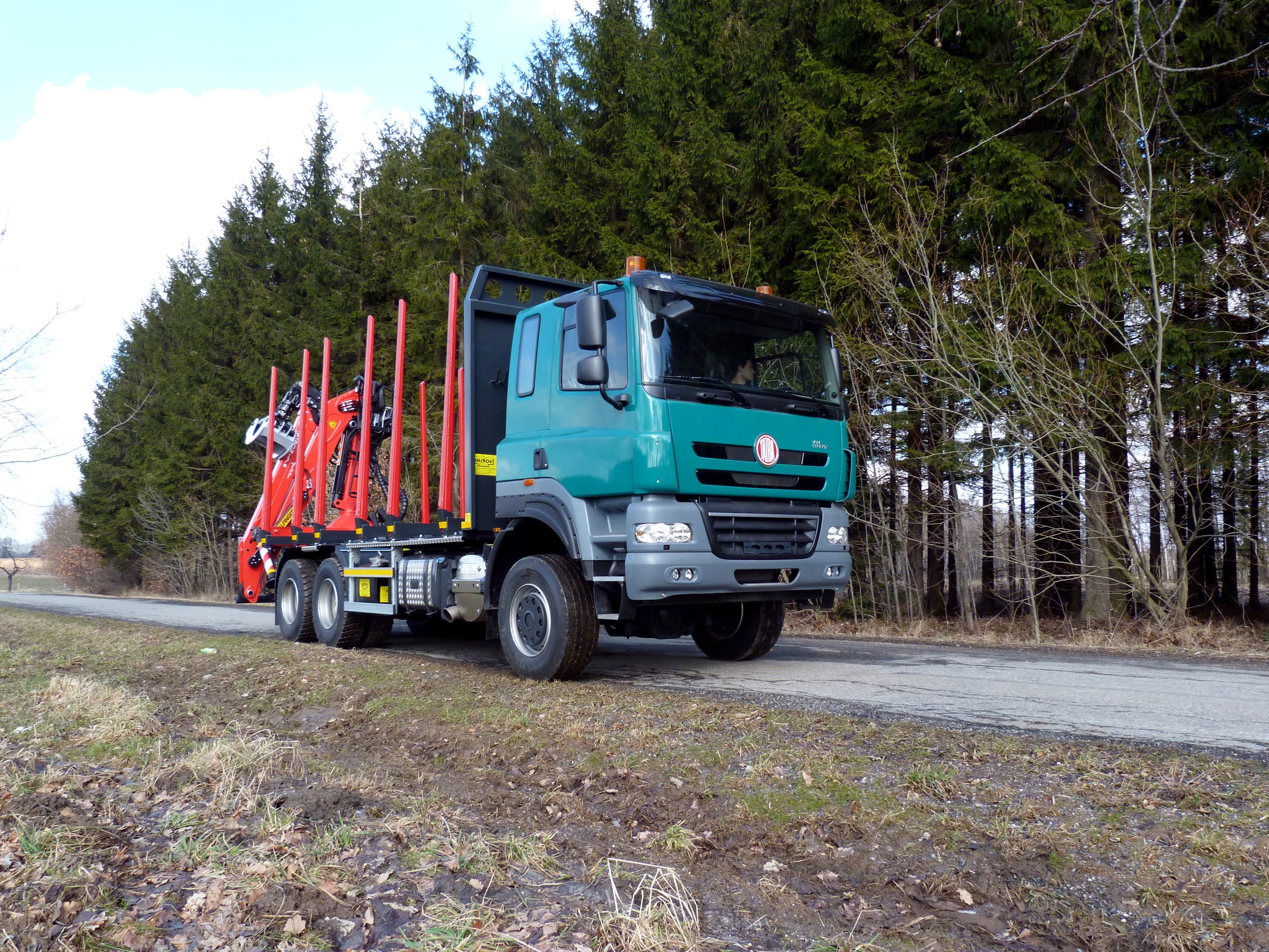 Green logging truck with a crane on a forest road HD Wallpaper