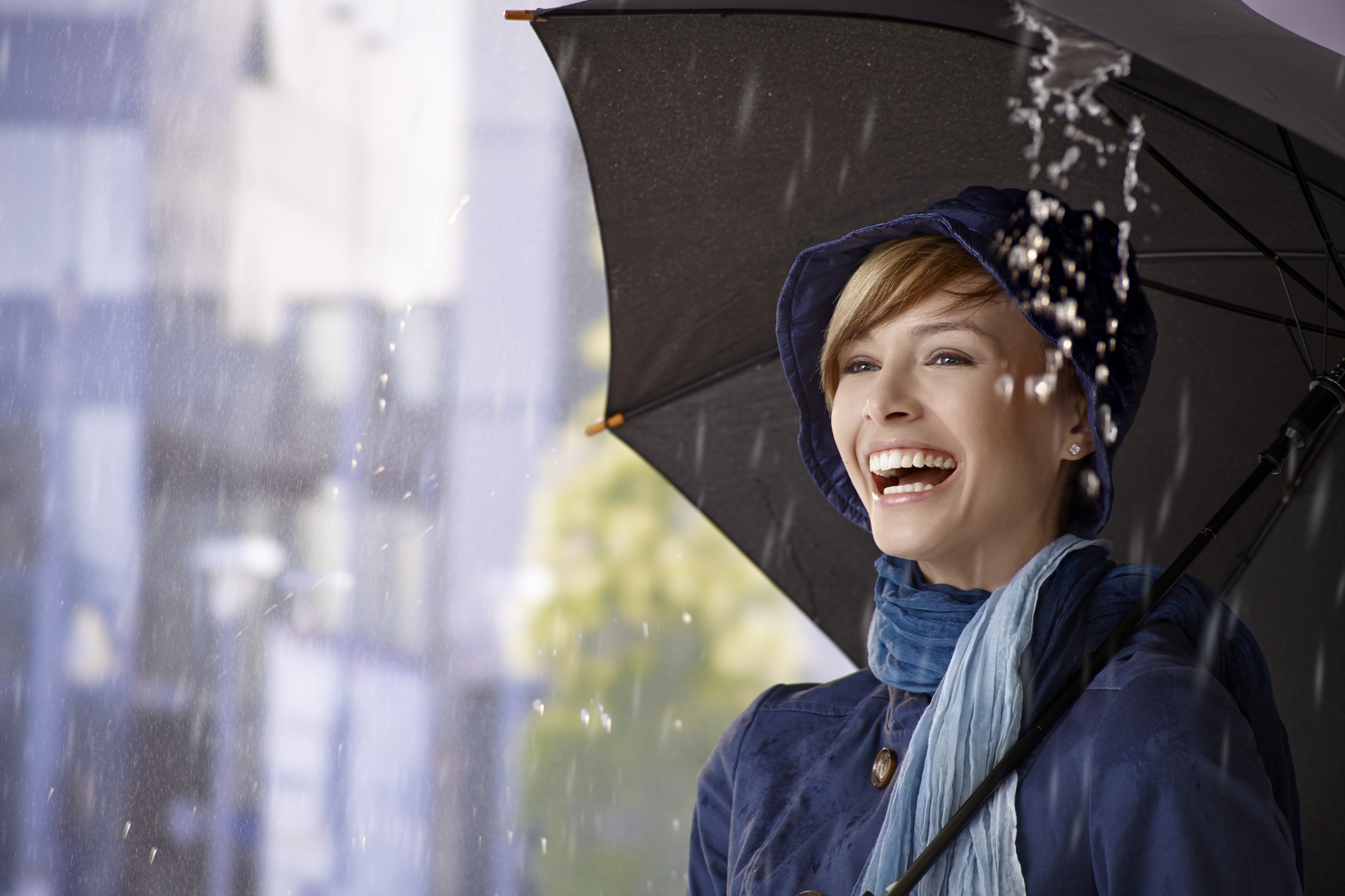 Blonde woman laughing under an umbrella in the rain HD Wallpaper