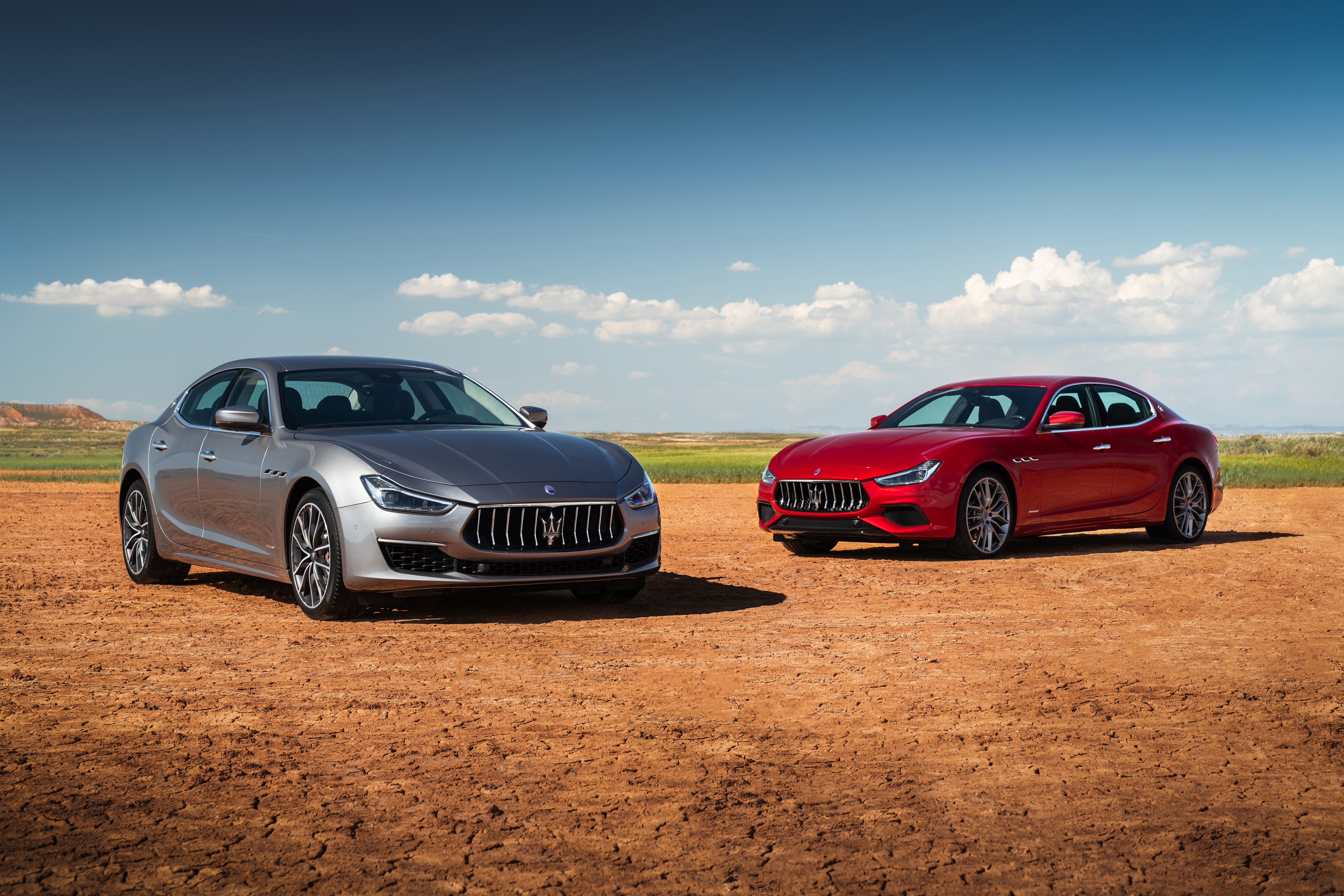 Two Maserati Ghibli cars in a desert landscape HD Wallpaper