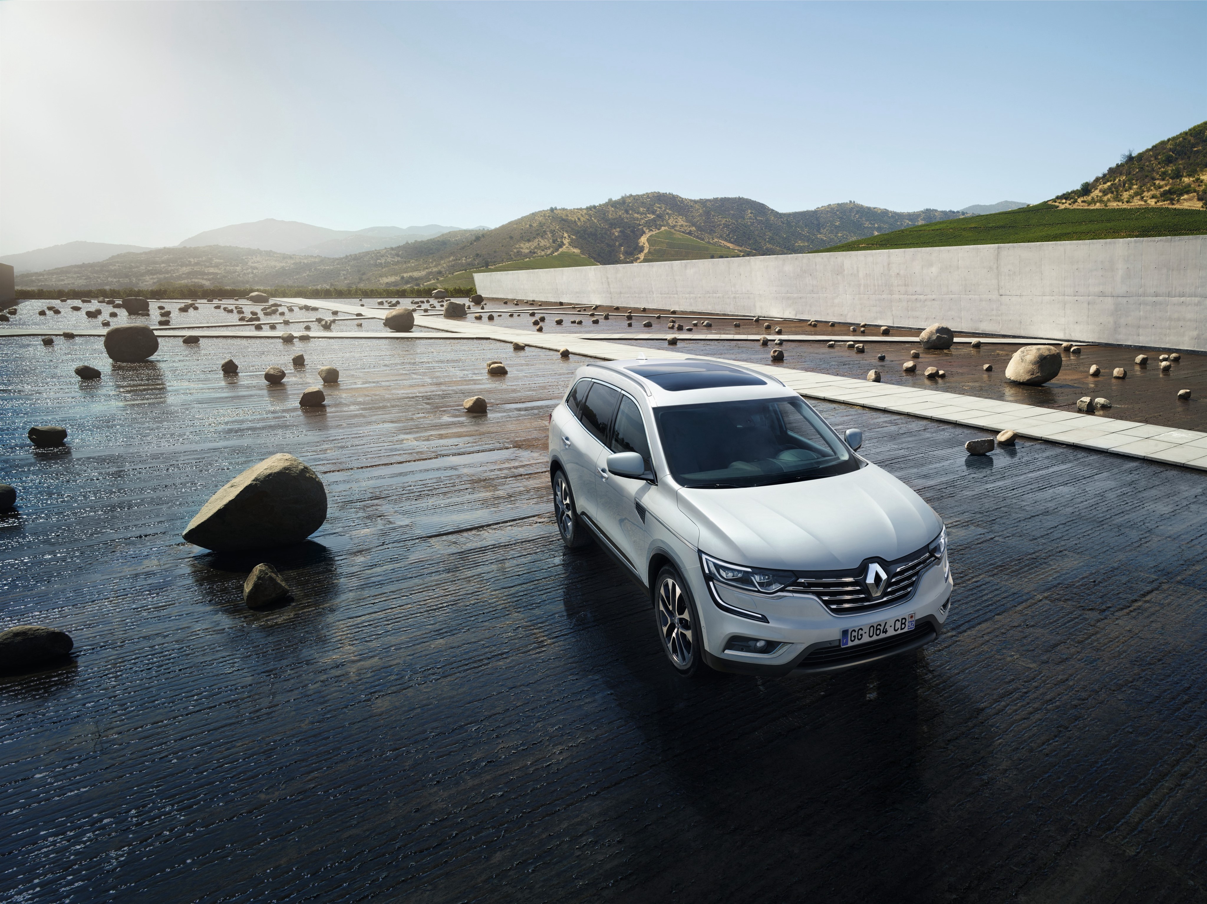 White Renault Koleos SUV on a wet surface with rocks HD Wallpaper
