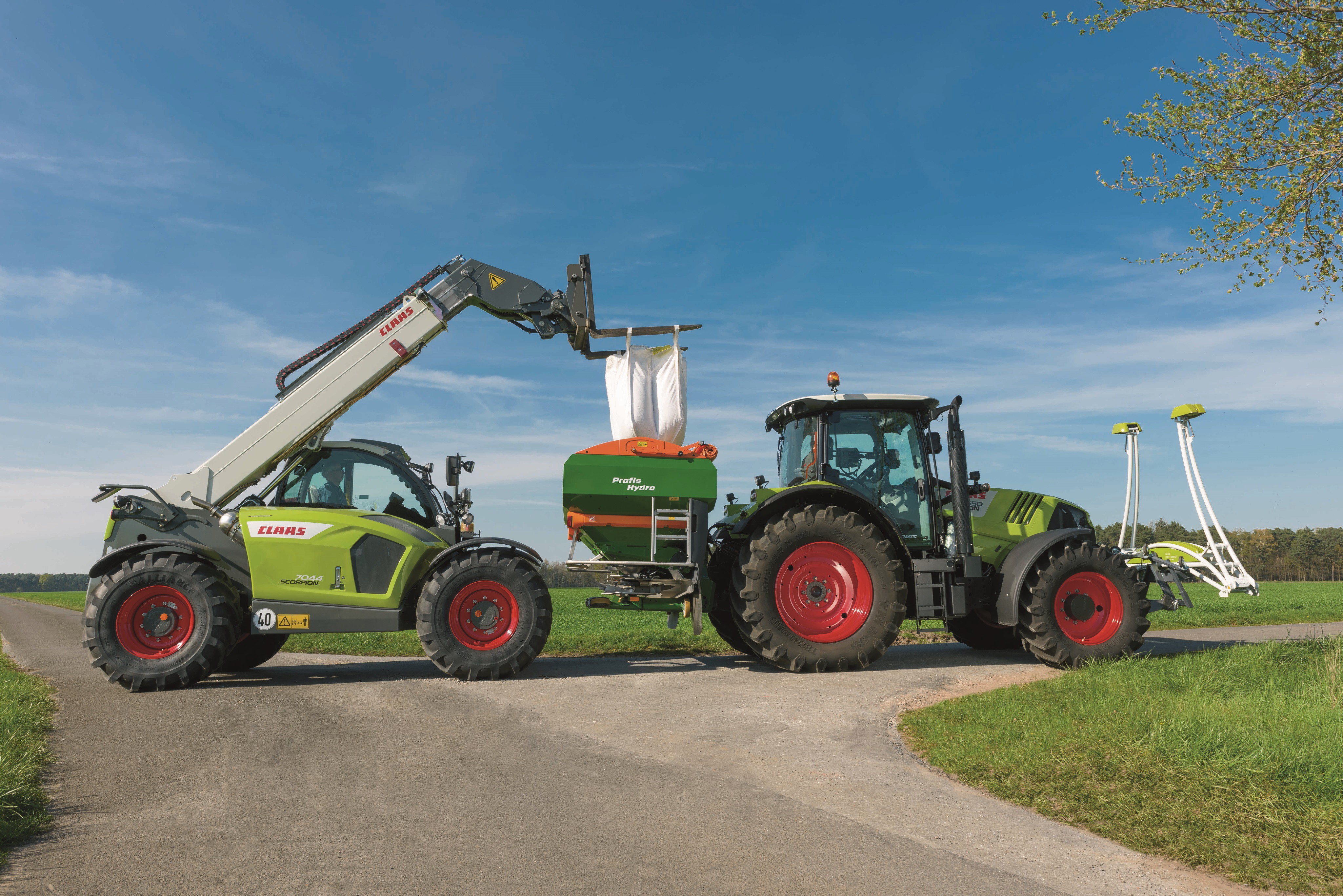 Claas Scorpion 7044 loading Claas Arion 550 with fertilizer HD Wallpaper