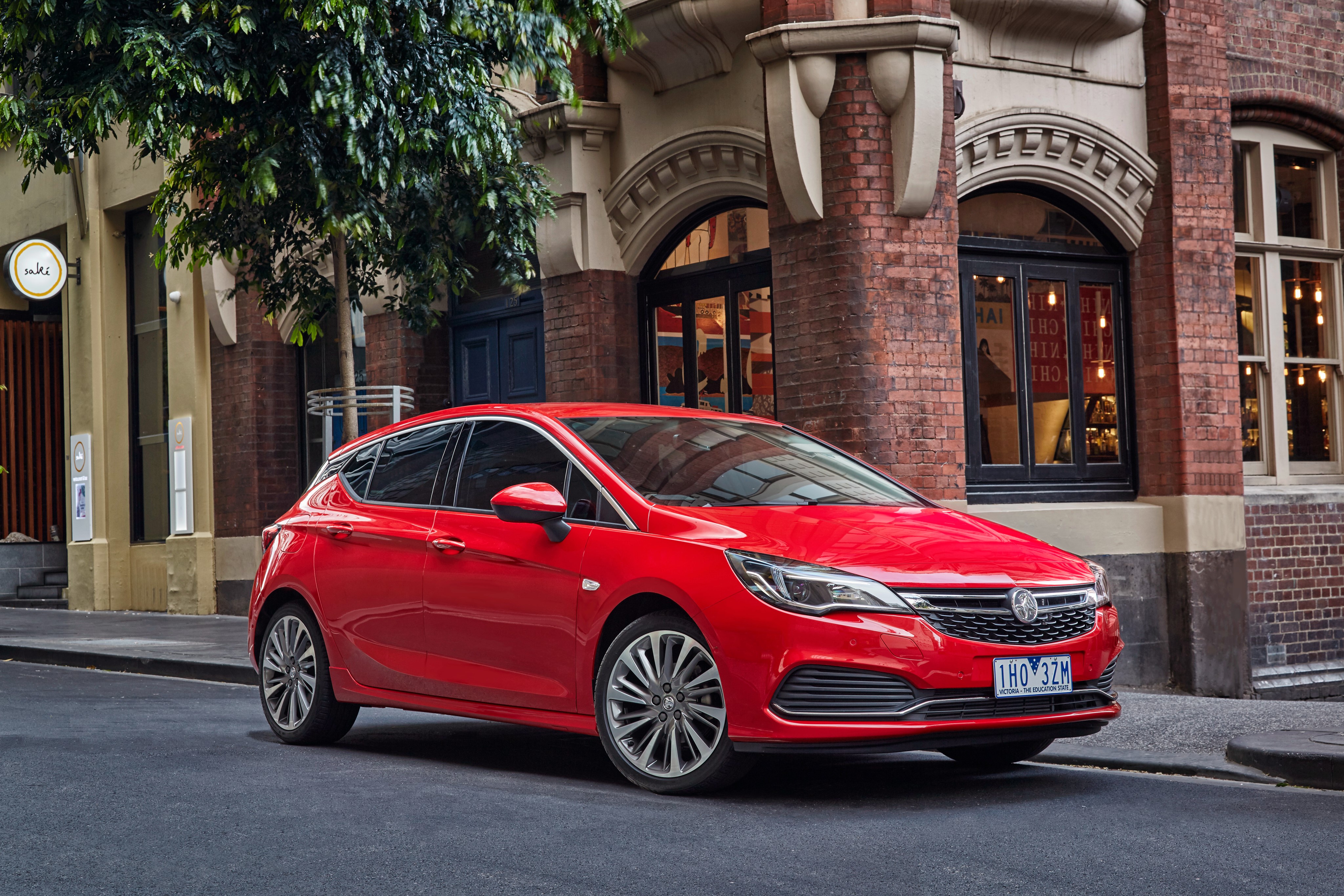 Red 2016 Holden Astra RSV parked on street HD Wallpaper