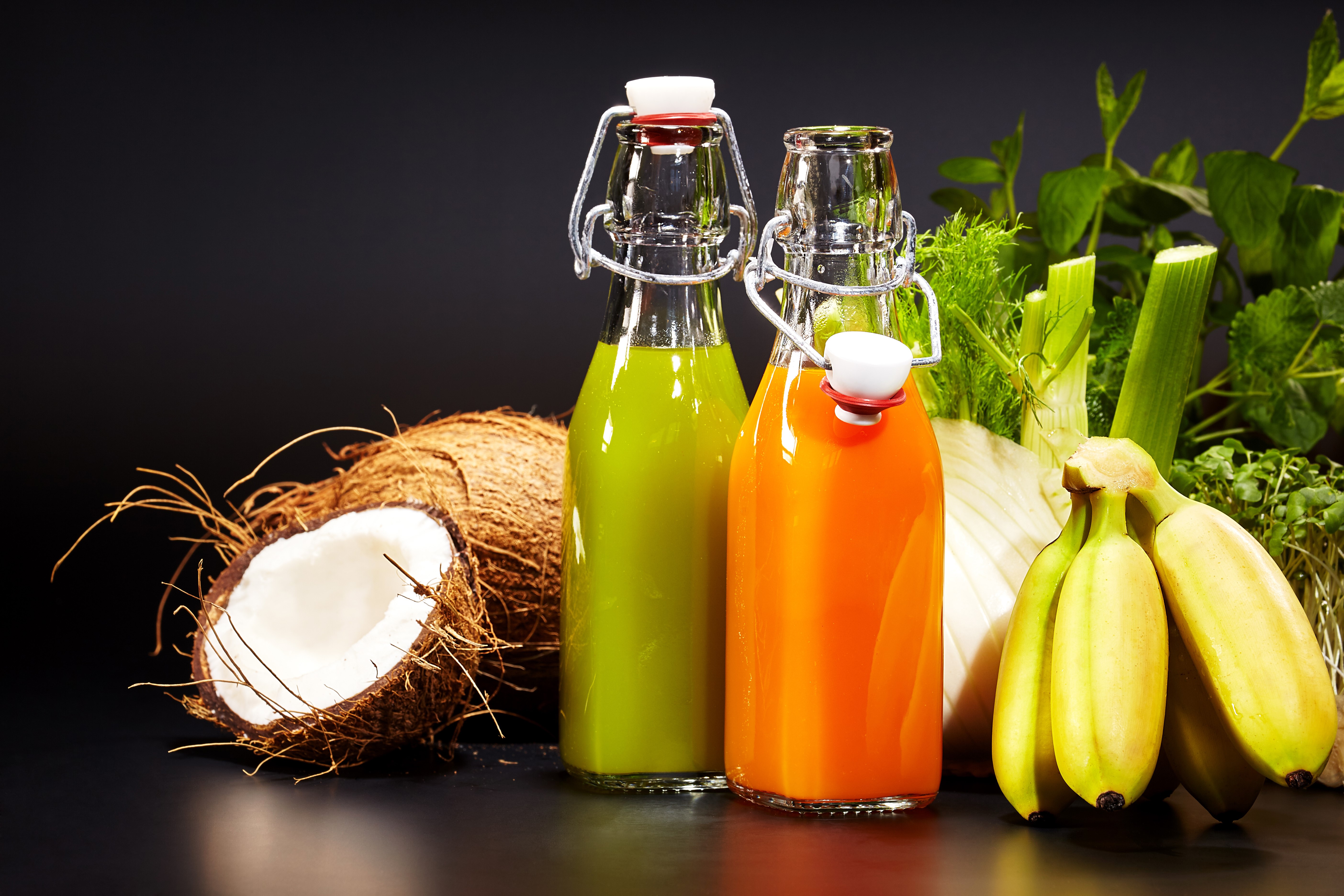 Two bottles of juice with bananas, coconuts, and vegetables HD Wallpaper