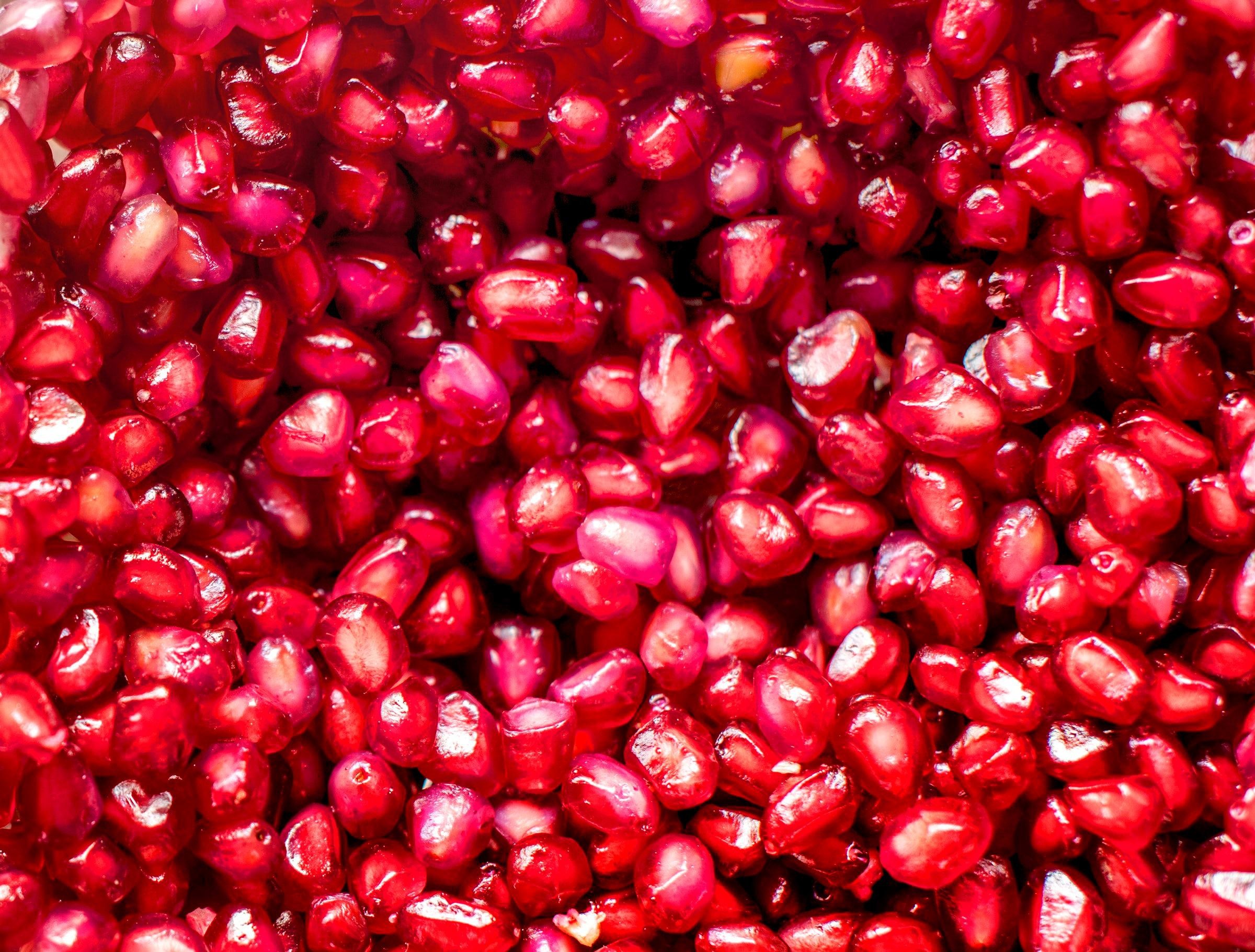 Close-up of glistening red pomegranate seeds HD Wallpaper