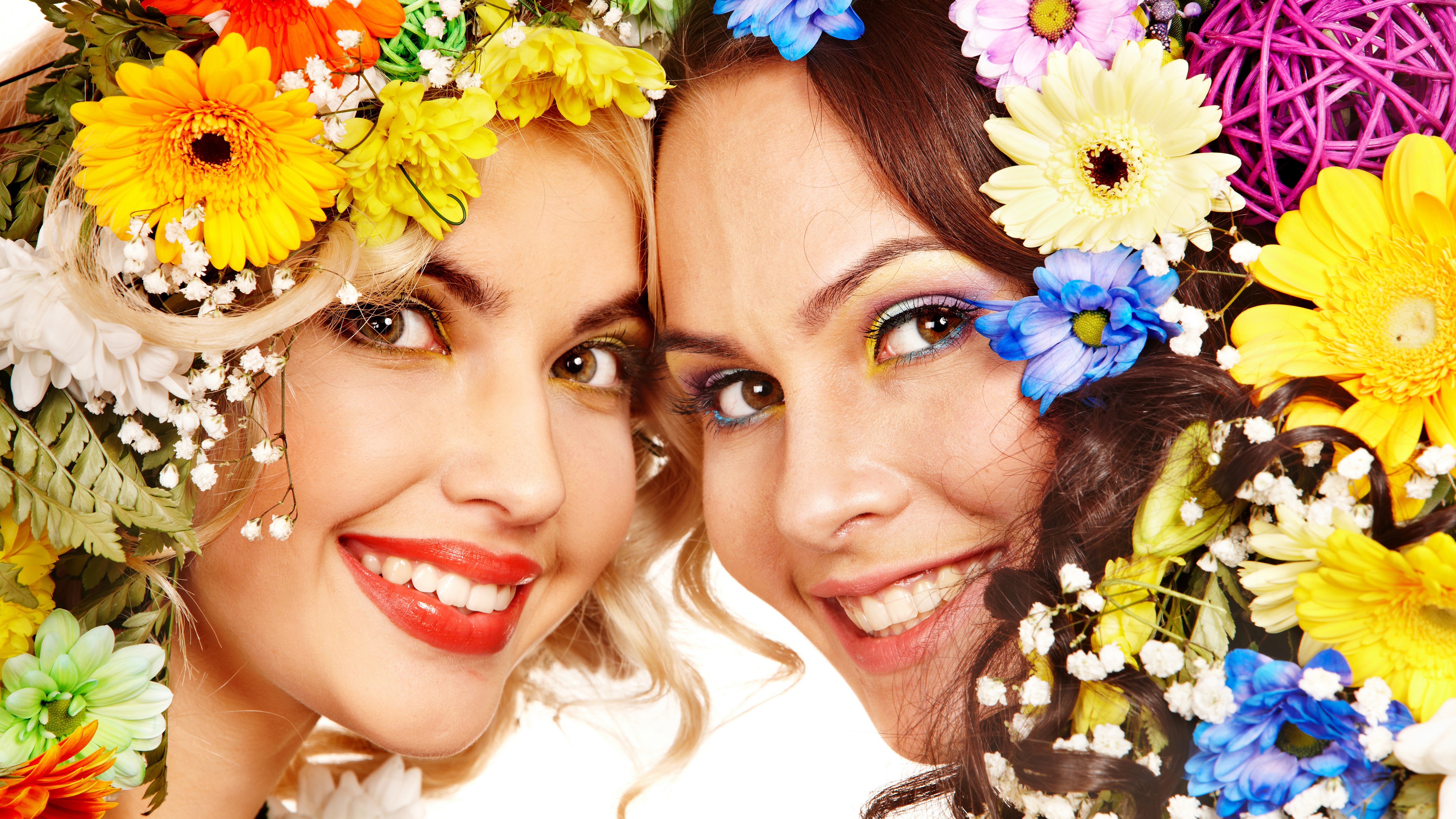 Two smiling women with flowers in their hair HD Wallpaper