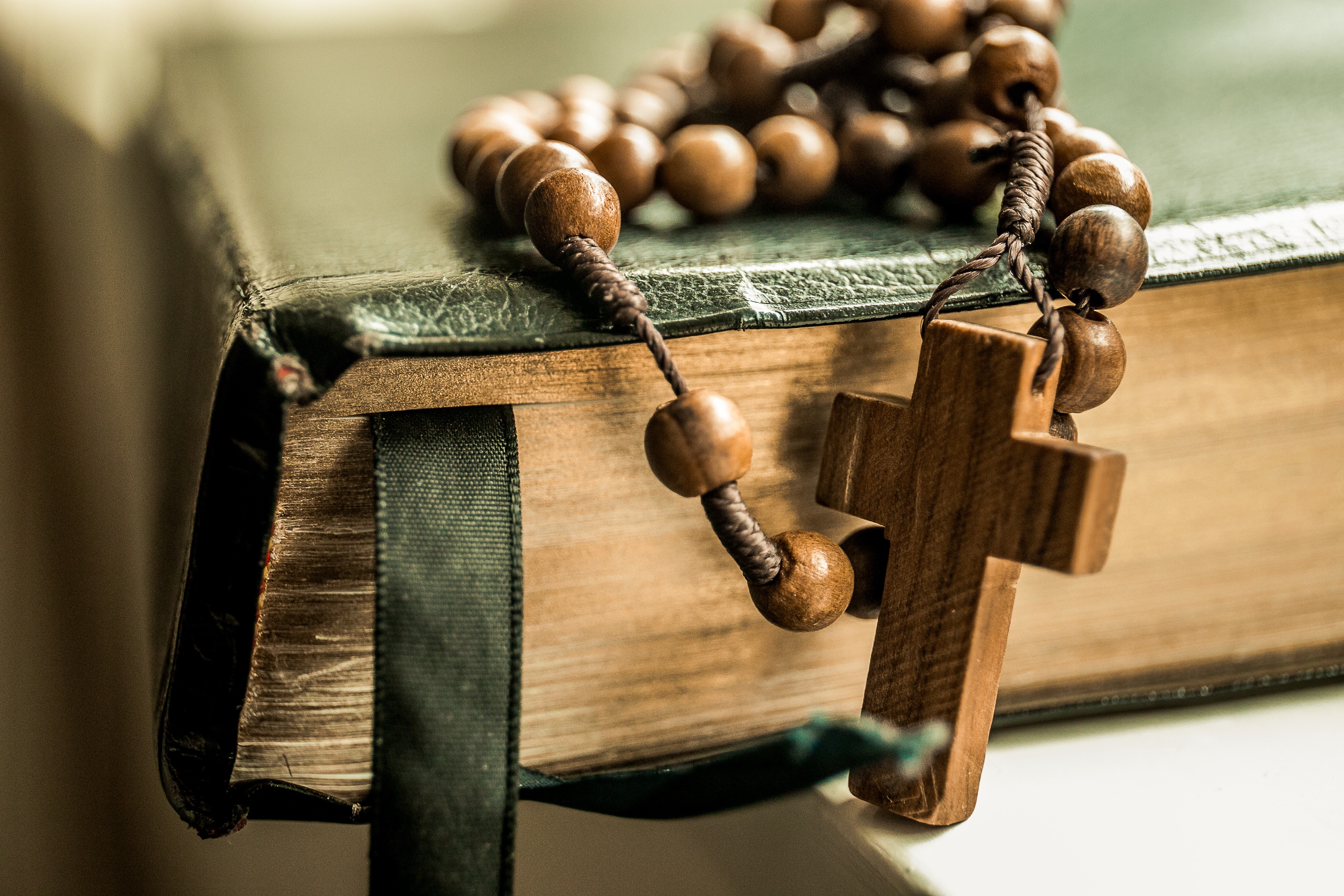 Rosary beads and cross on a book HD Wallpaper