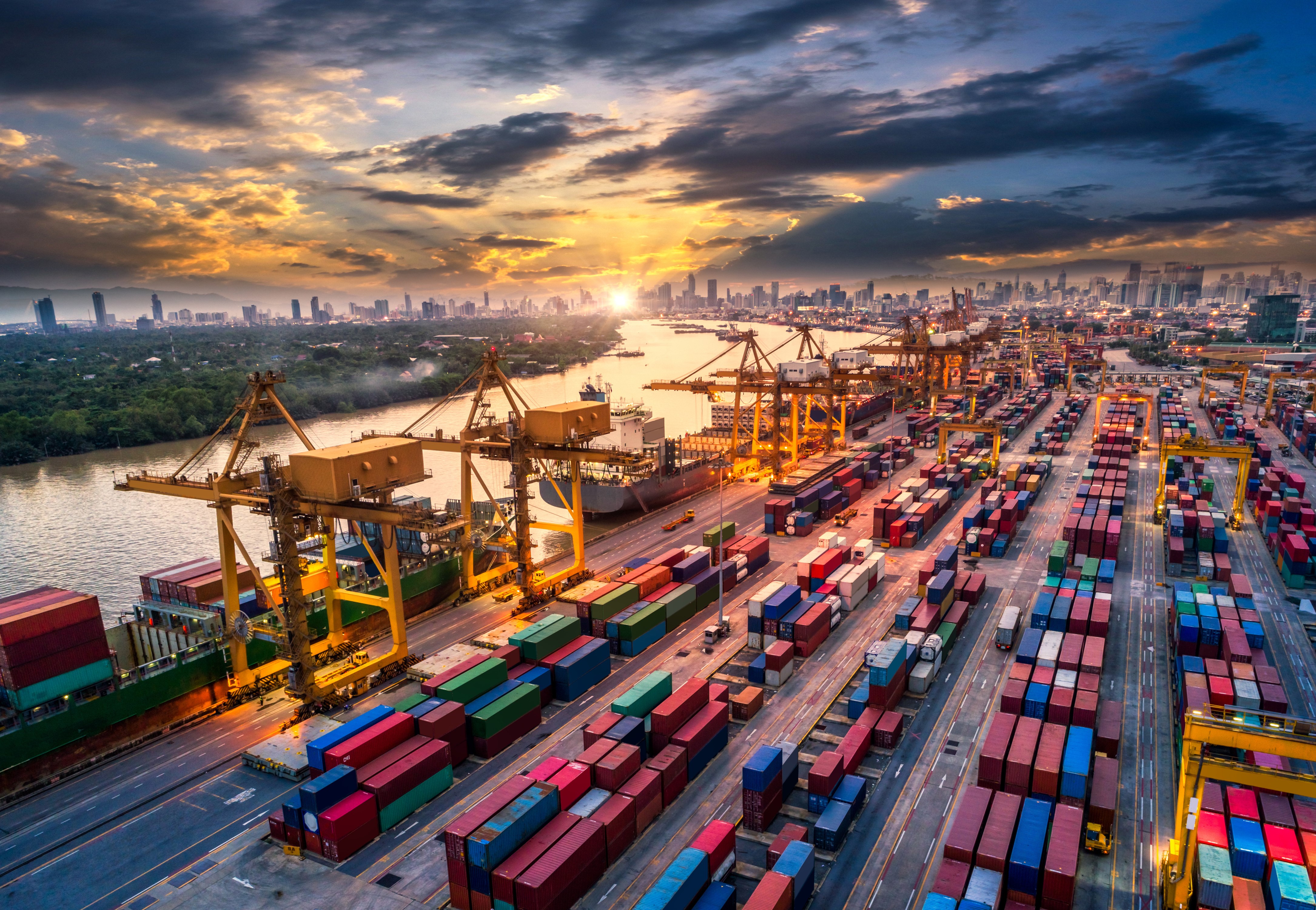 Container ship port at sunset with city skyline HD Wallpaper