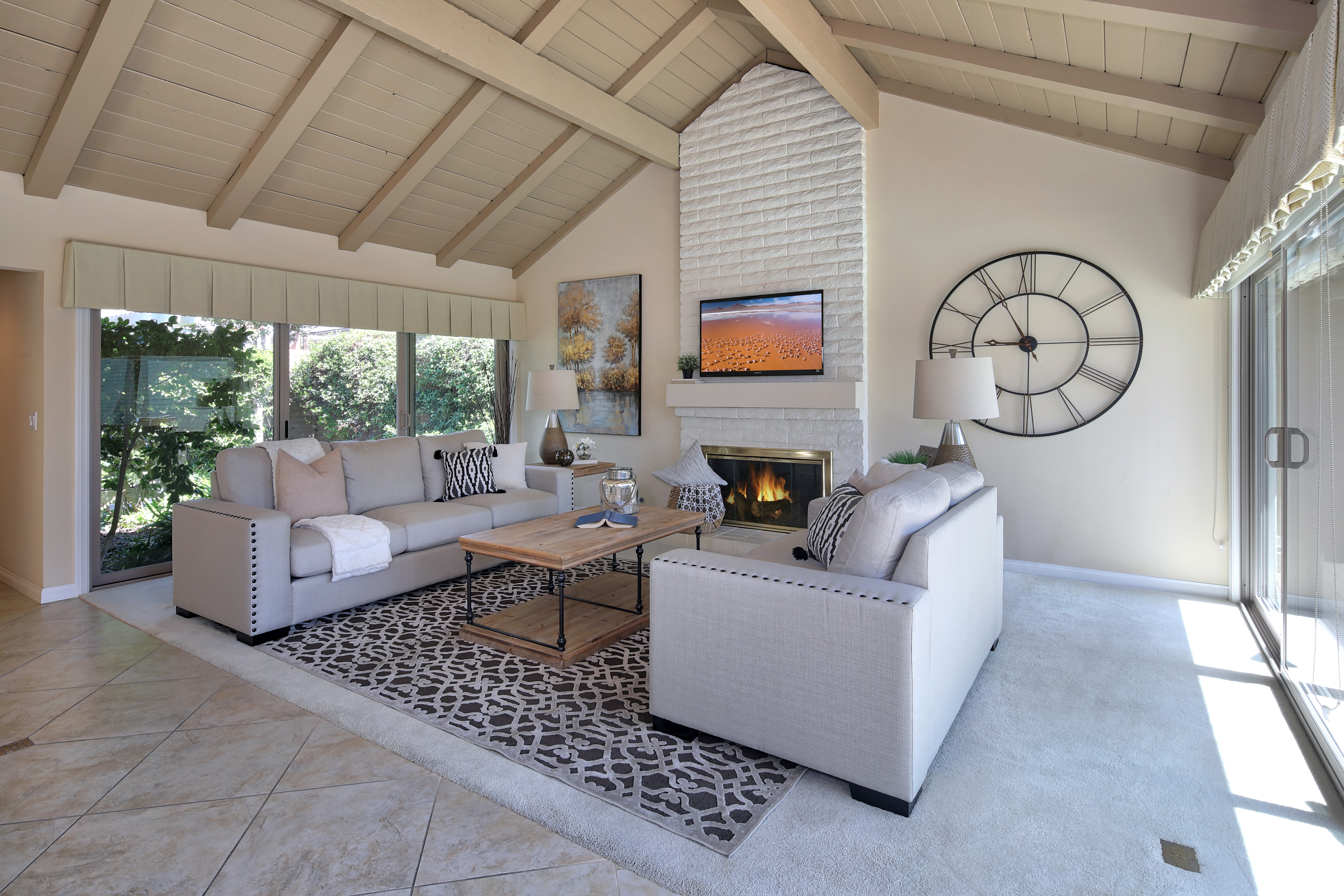 Living room with sofas, fireplace, and large clock HD Wallpaper