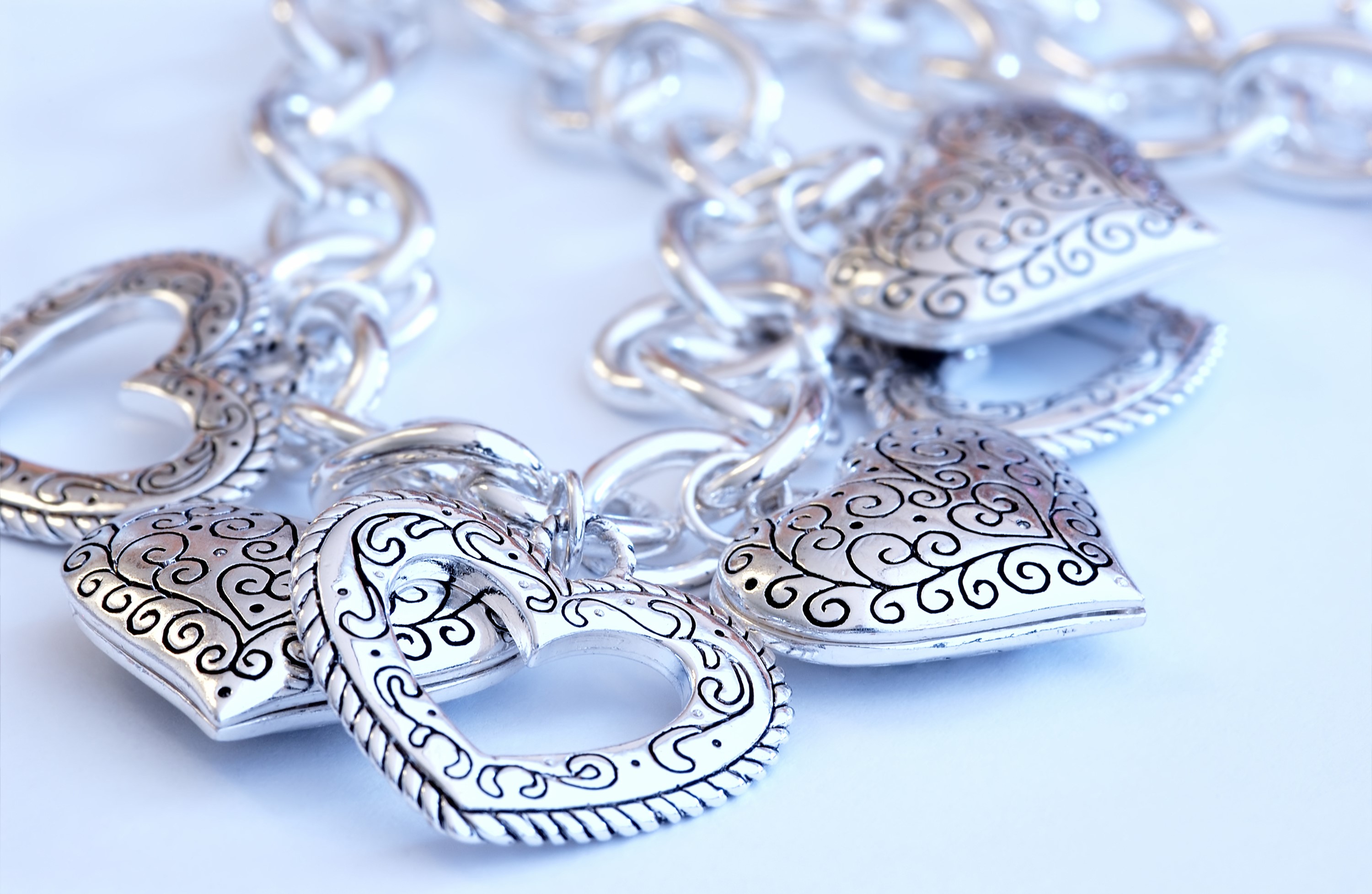 Silver heart charm bracelet with ornate details HD Wallpaper