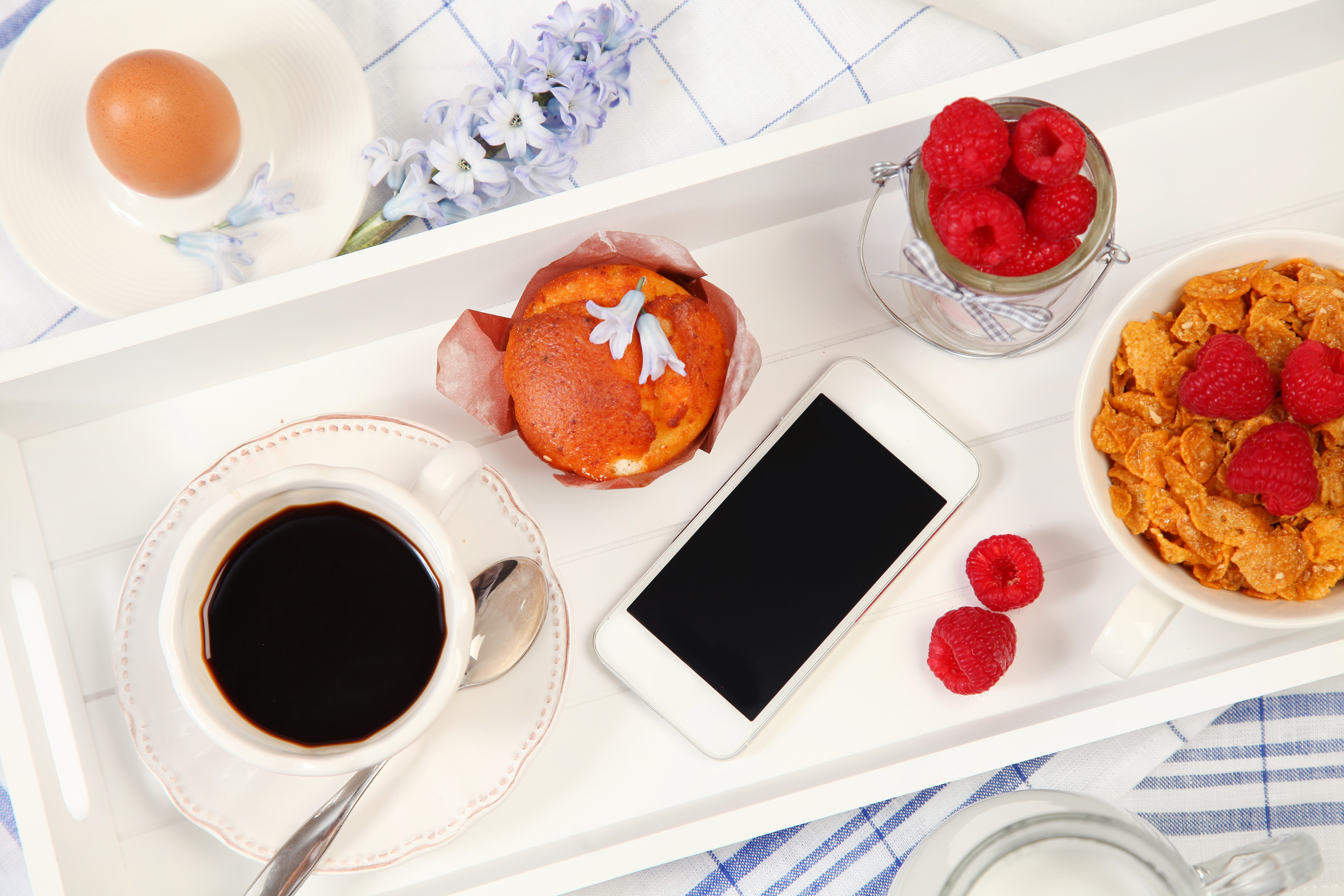 Breakfast tray with coffee, muffin, egg, cereal, raspberries, and smartphone HD Wallpaper