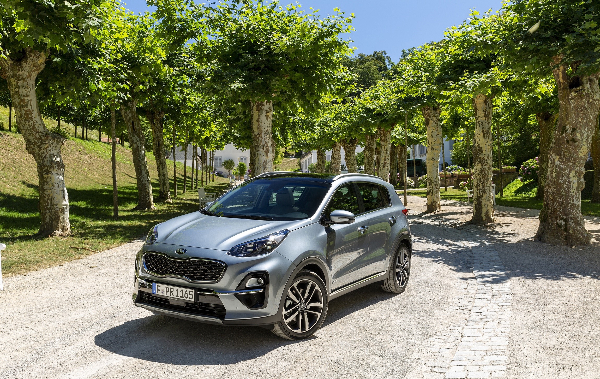 Grey Kia Sportage parked on a gravel path HD Wallpaper