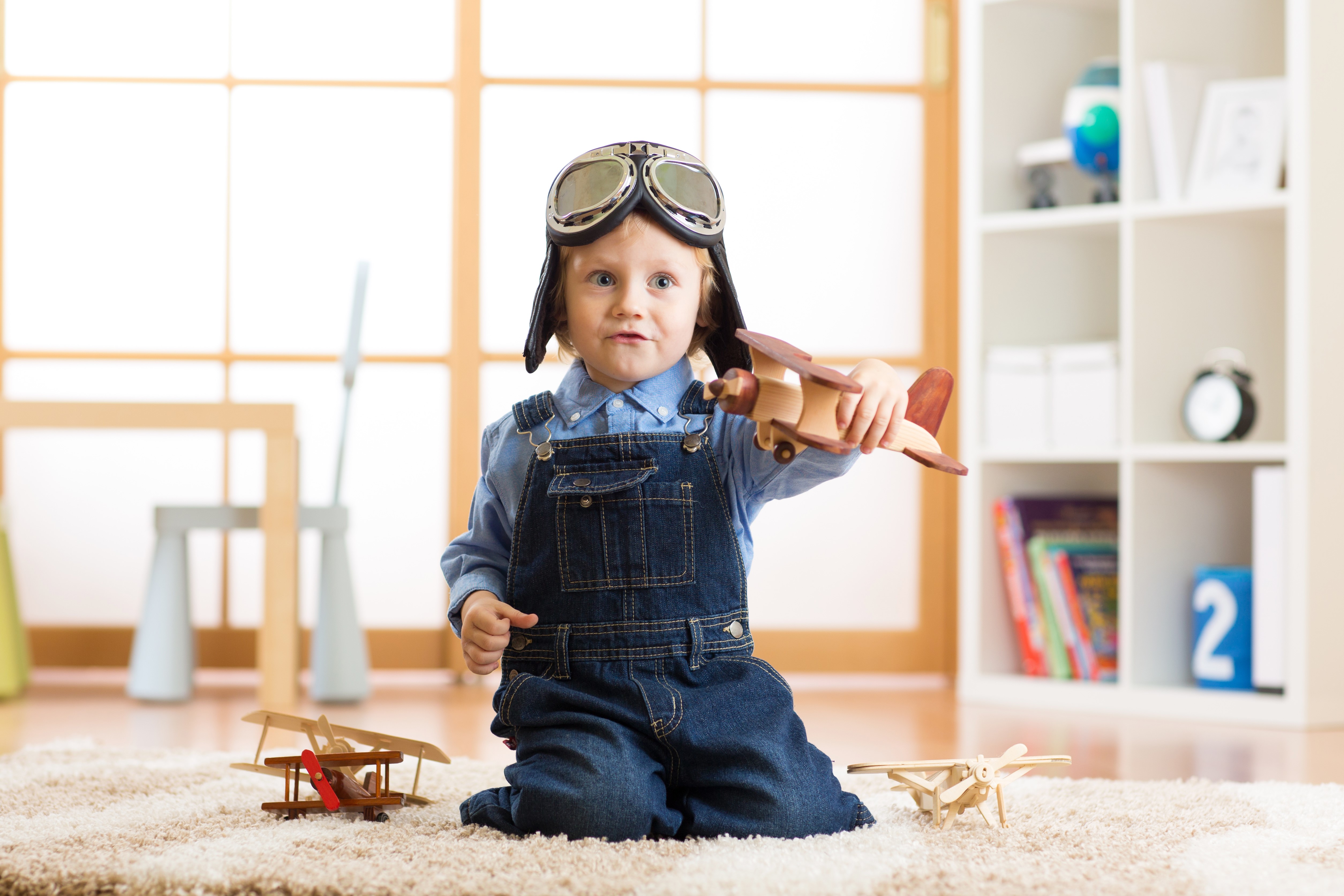 Boy in pilot costume playing with toy airplanes HD Wallpaper