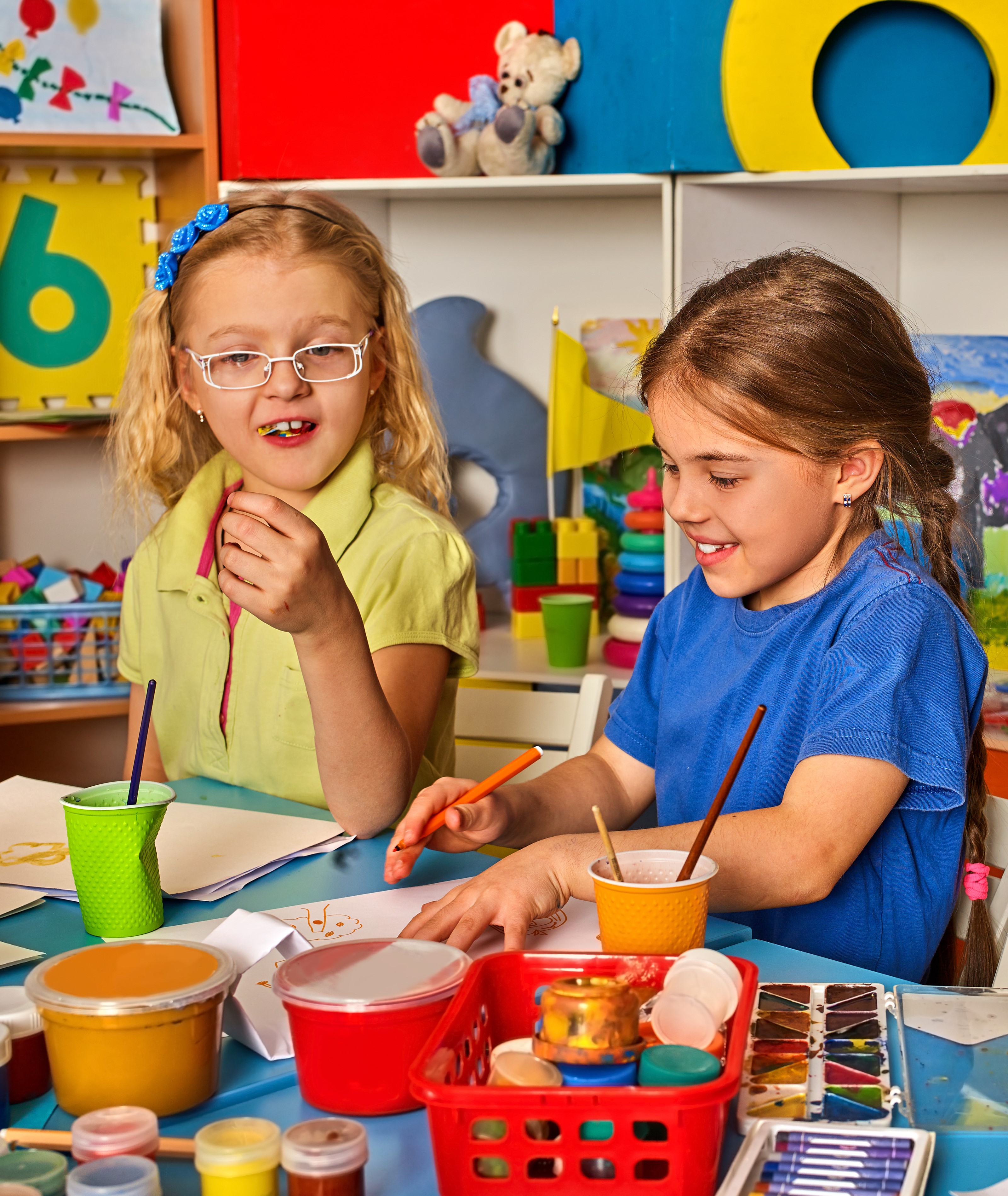 Two young girls painting at a table HD Wallpaper
