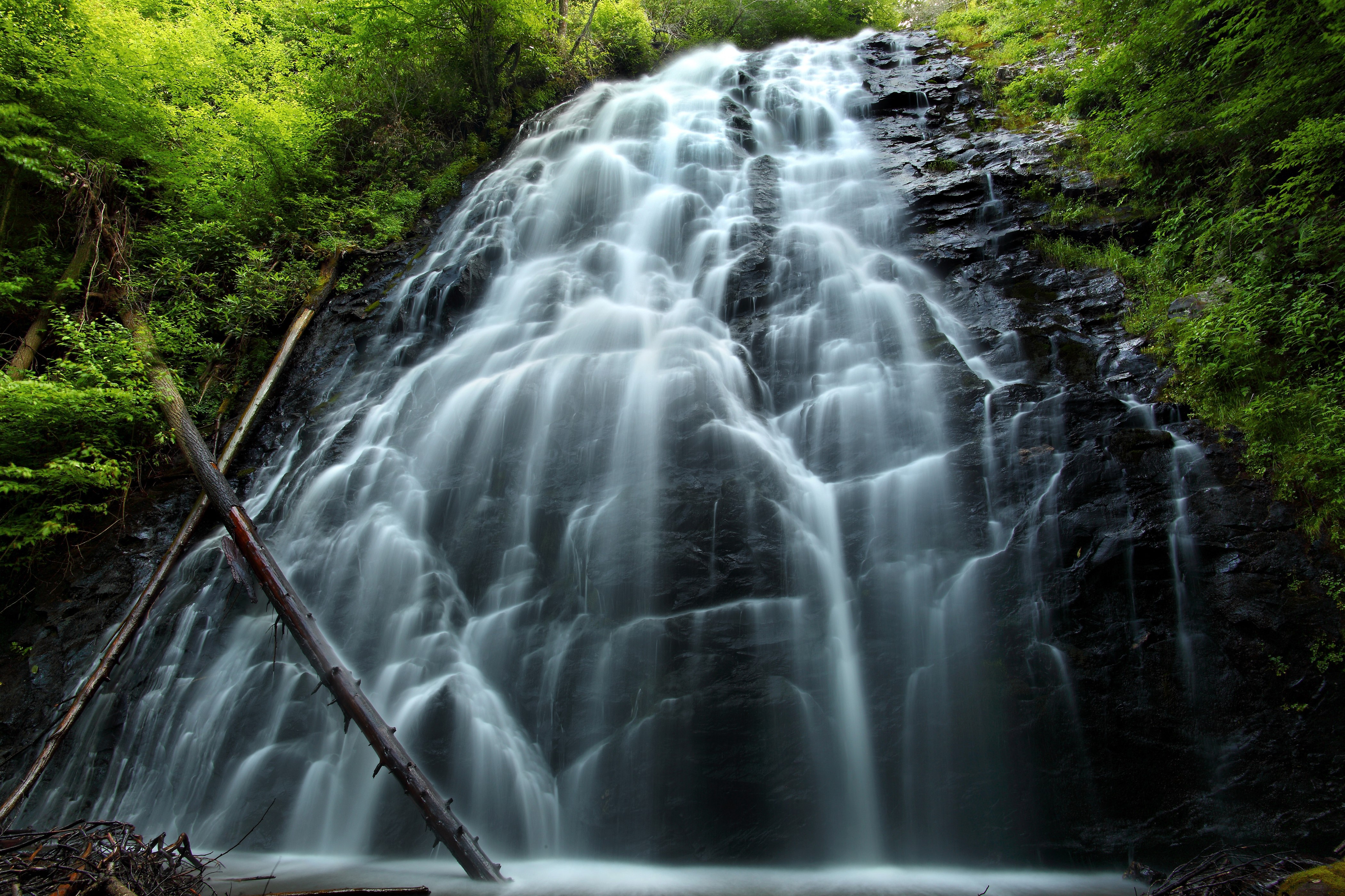 Waterfall cascading down a rocky cliff with trees HD Wallpaper