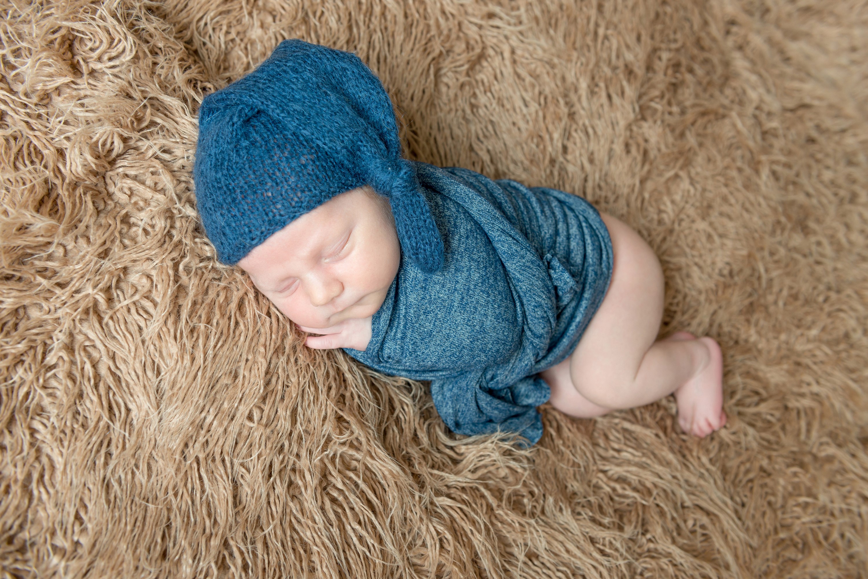 Newborn baby sleeping in a blue hat and swaddle HD Wallpaper