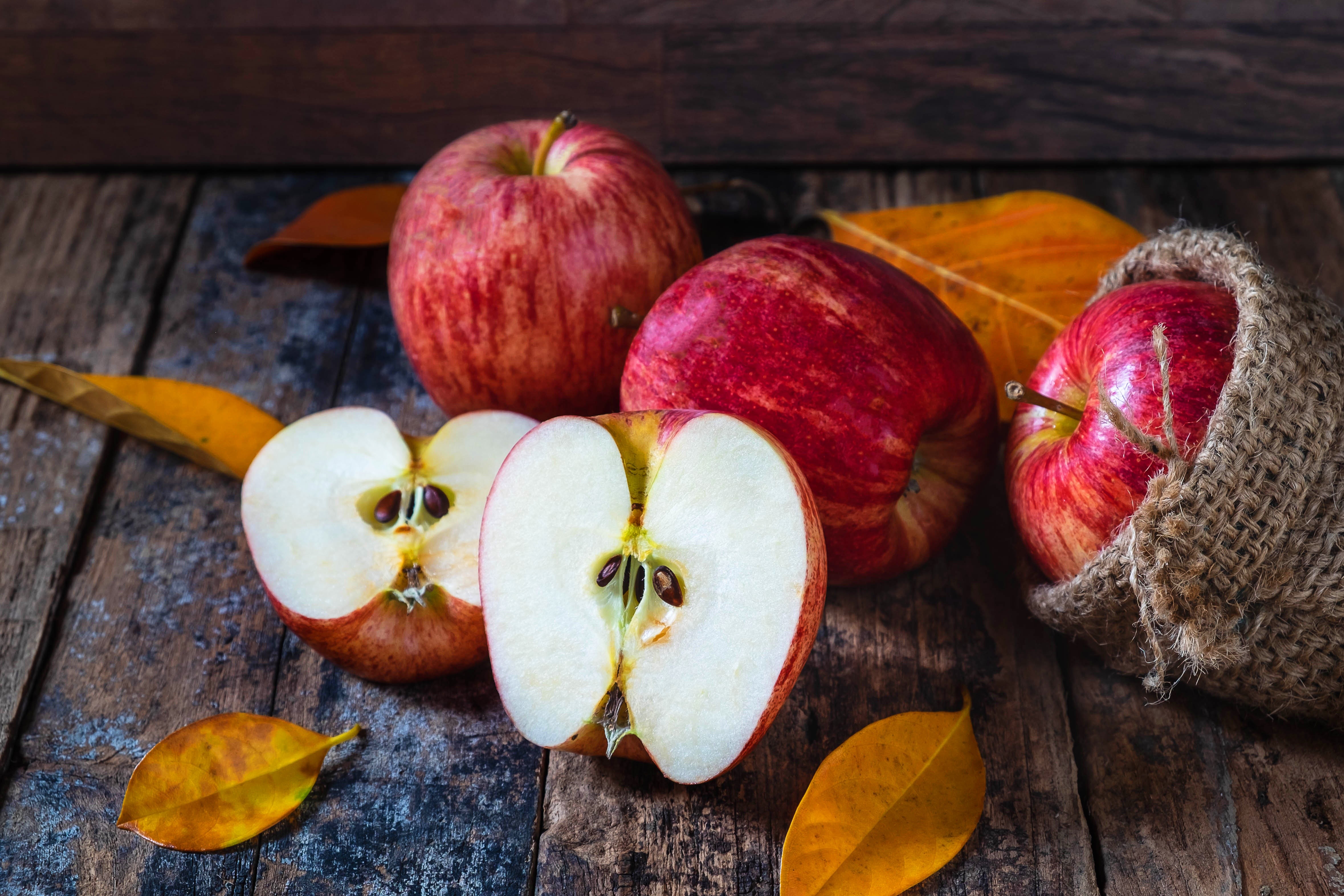 Apples in a burlap sack with autumn leaves HD Wallpaper