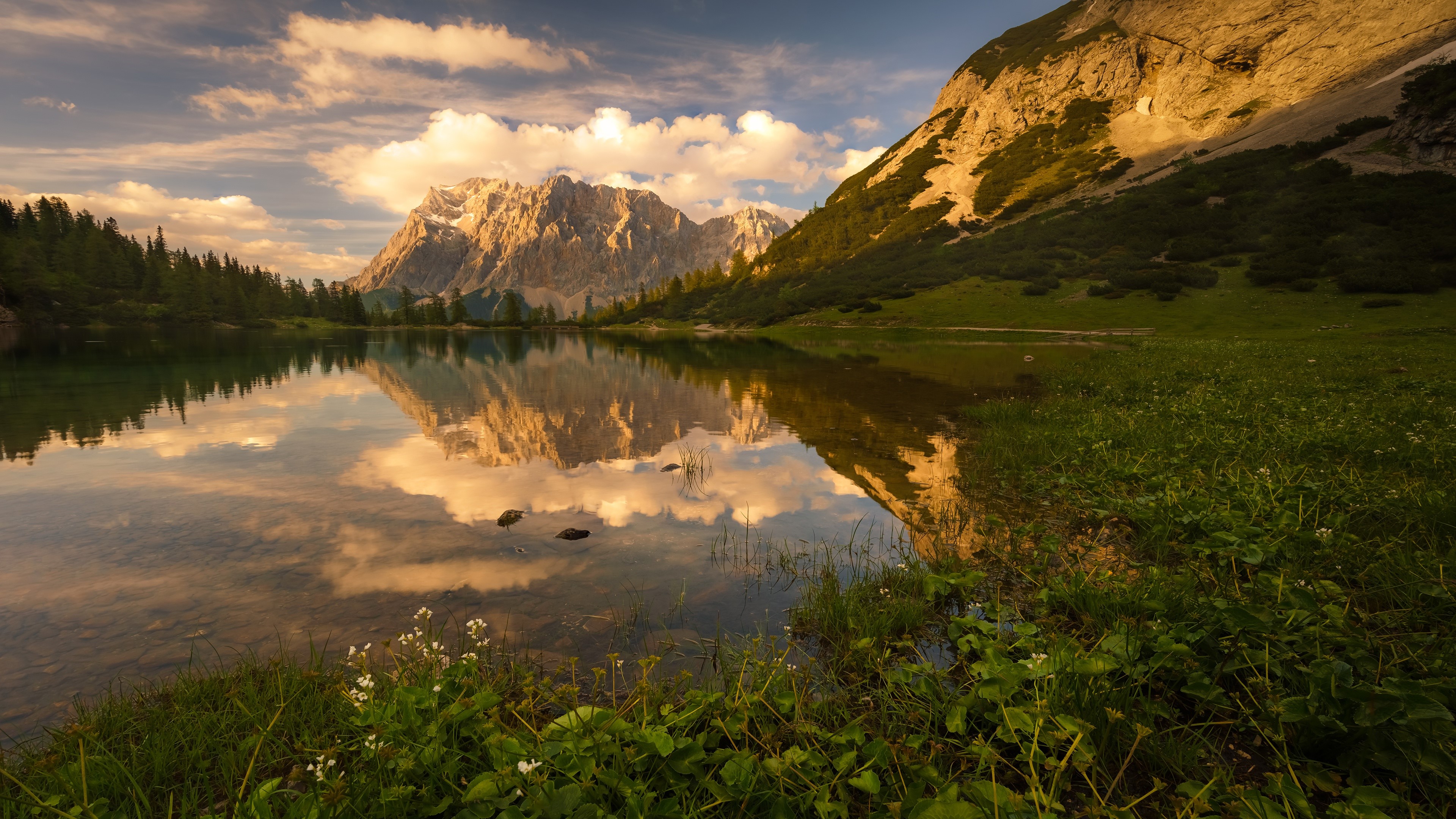 Mountains reflected in a lake at sunset HD Wallpaper
