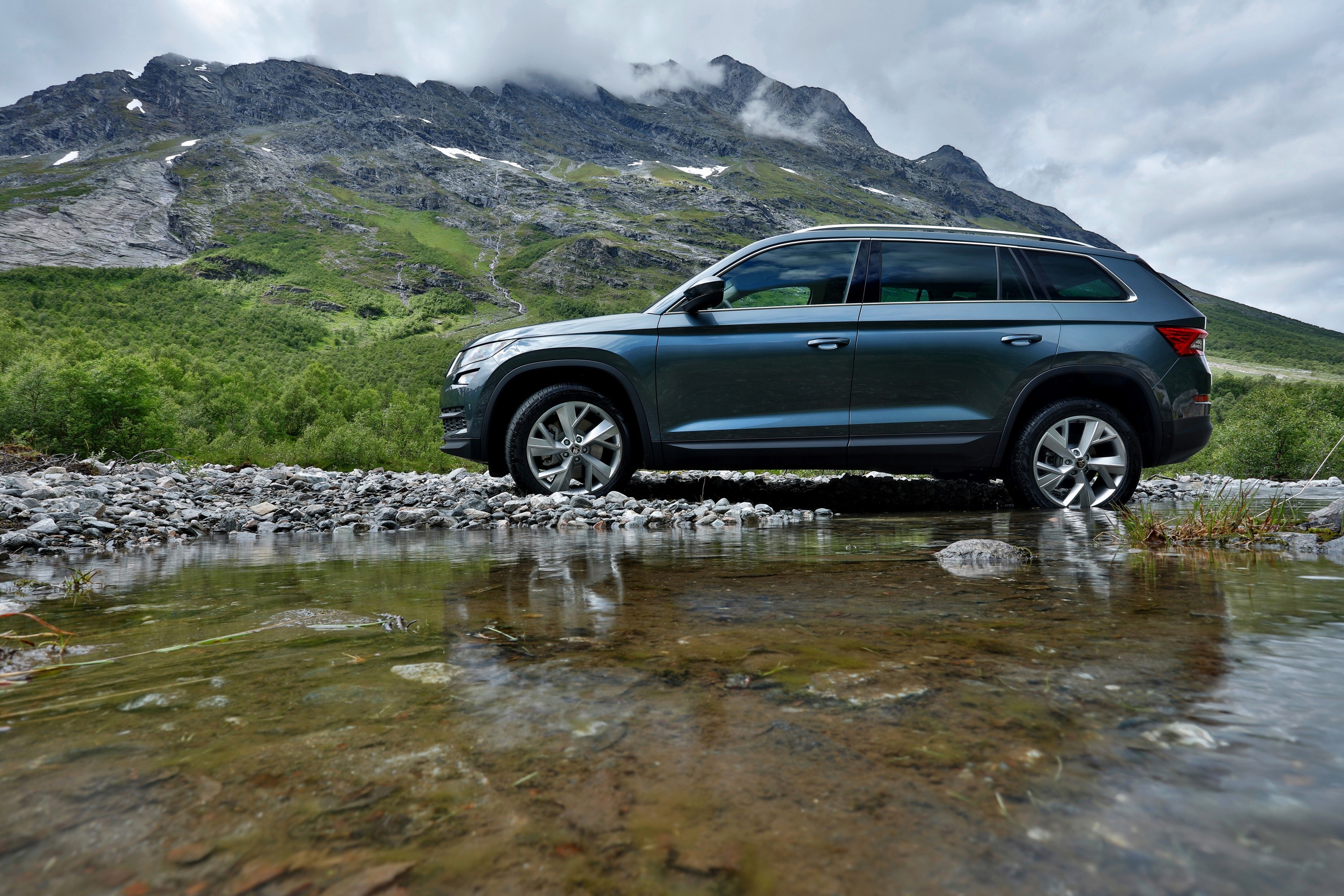 Skoda Kodiaq SUV on a rocky riverbed with mountains HD Wallpaper