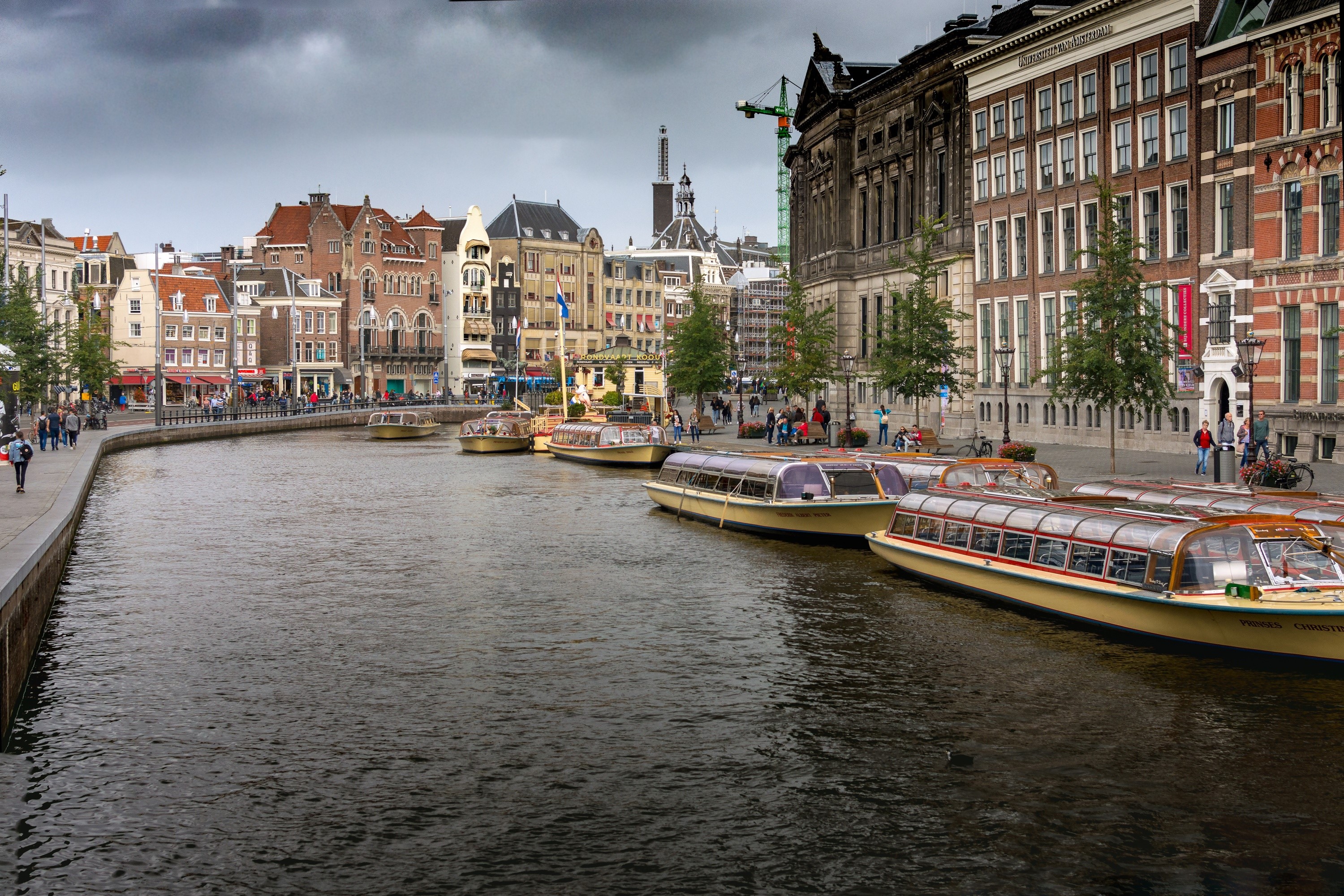 Amsterdam canal with tour boats and buildings HD Wallpaper