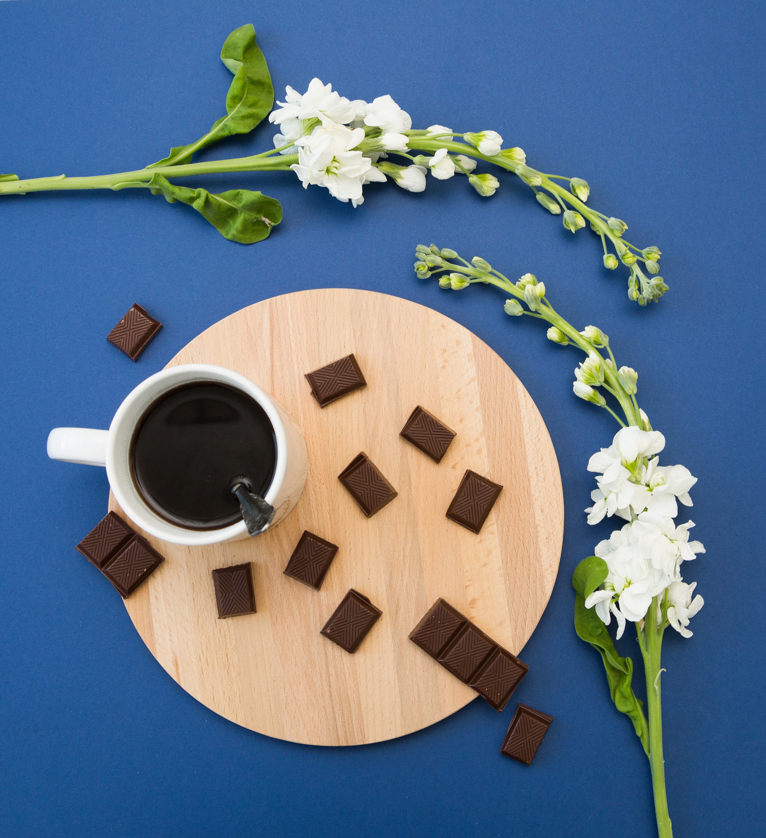 Coffee cup with chocolate and white flowers on blue background HD Wallpaper
