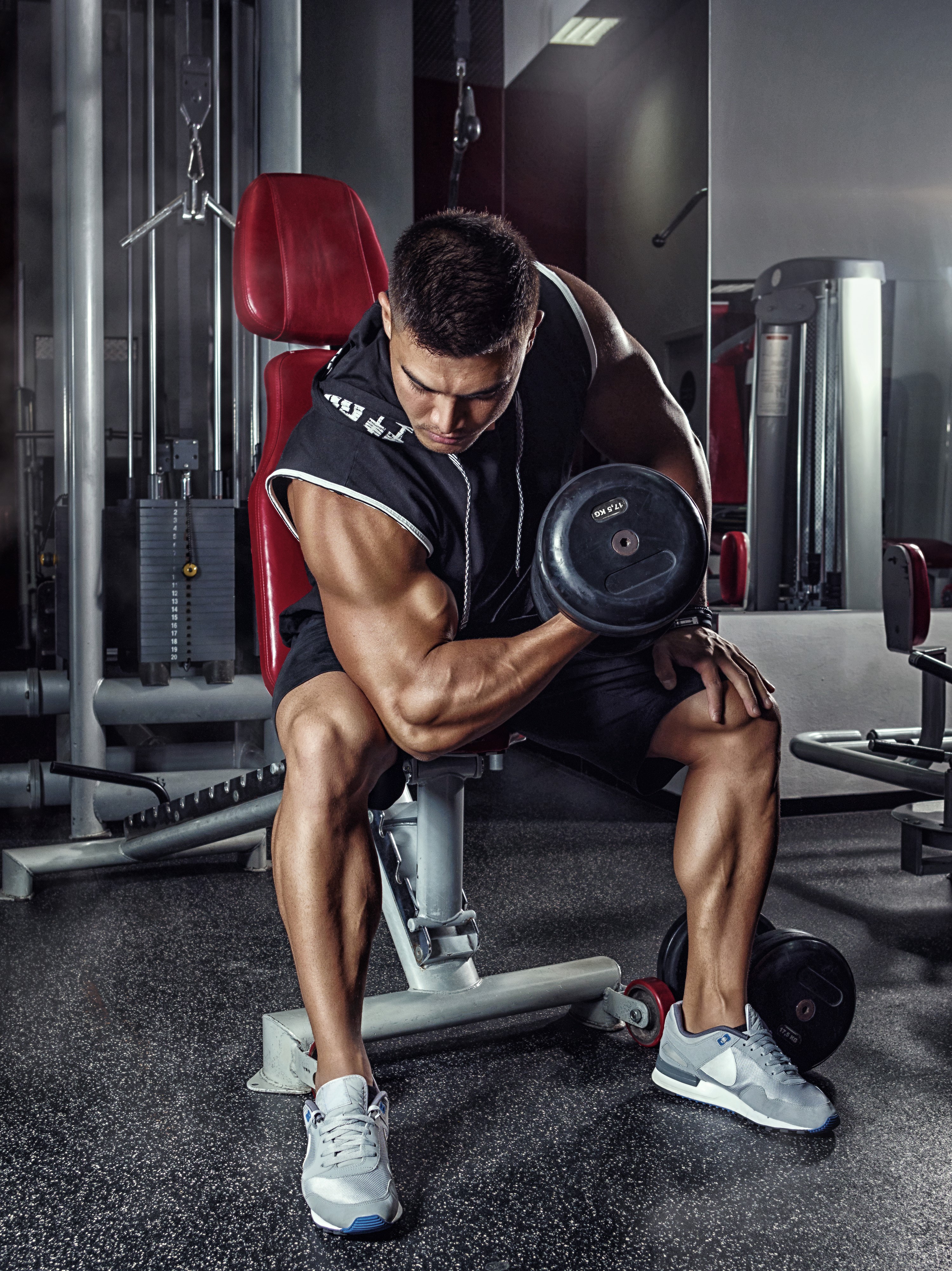 Man doing bicep curls with dumbbells in a gym HD Phone Wallpaper