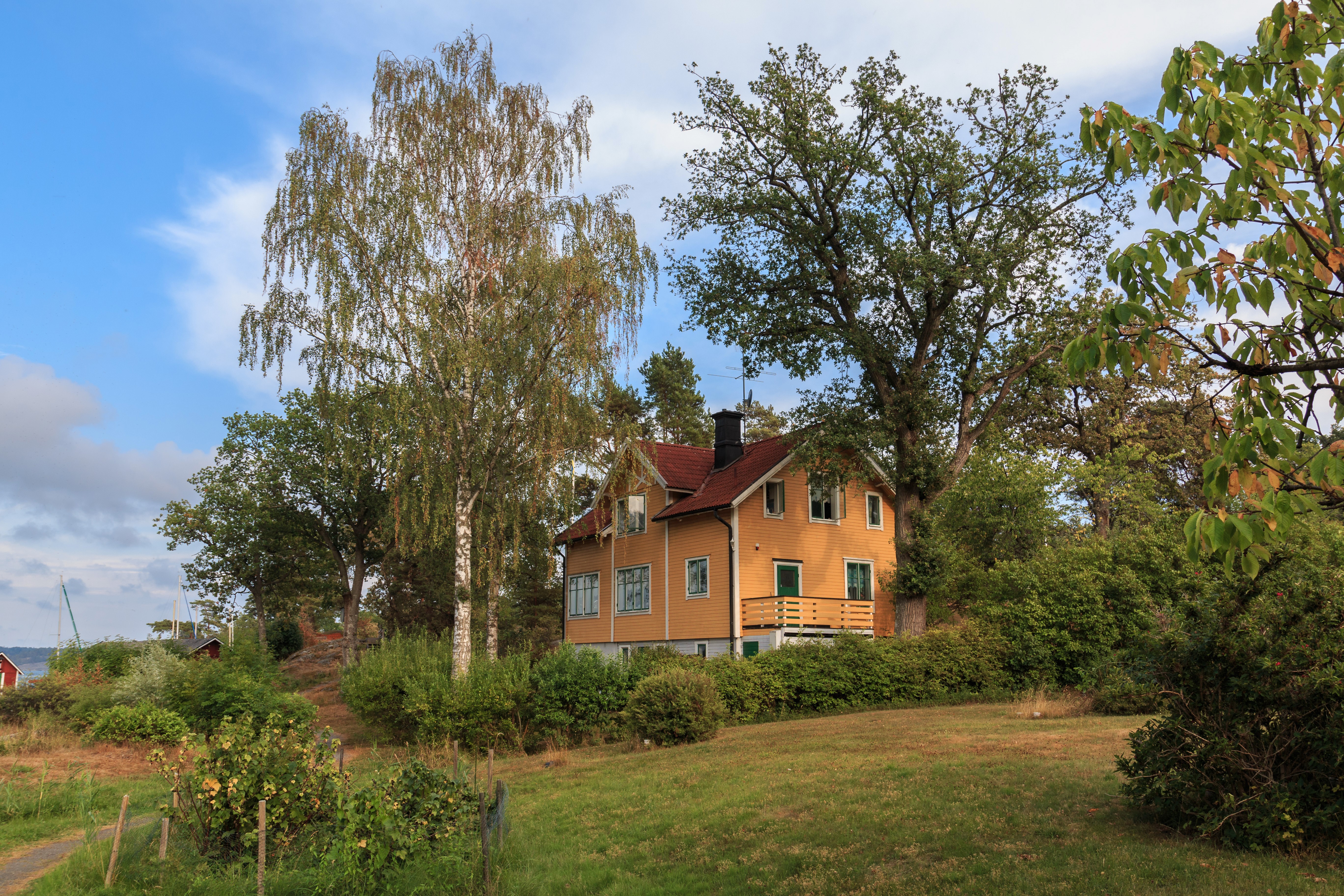 Yellow house in Saltsjobaden, Sweden with trees HD Wallpaper