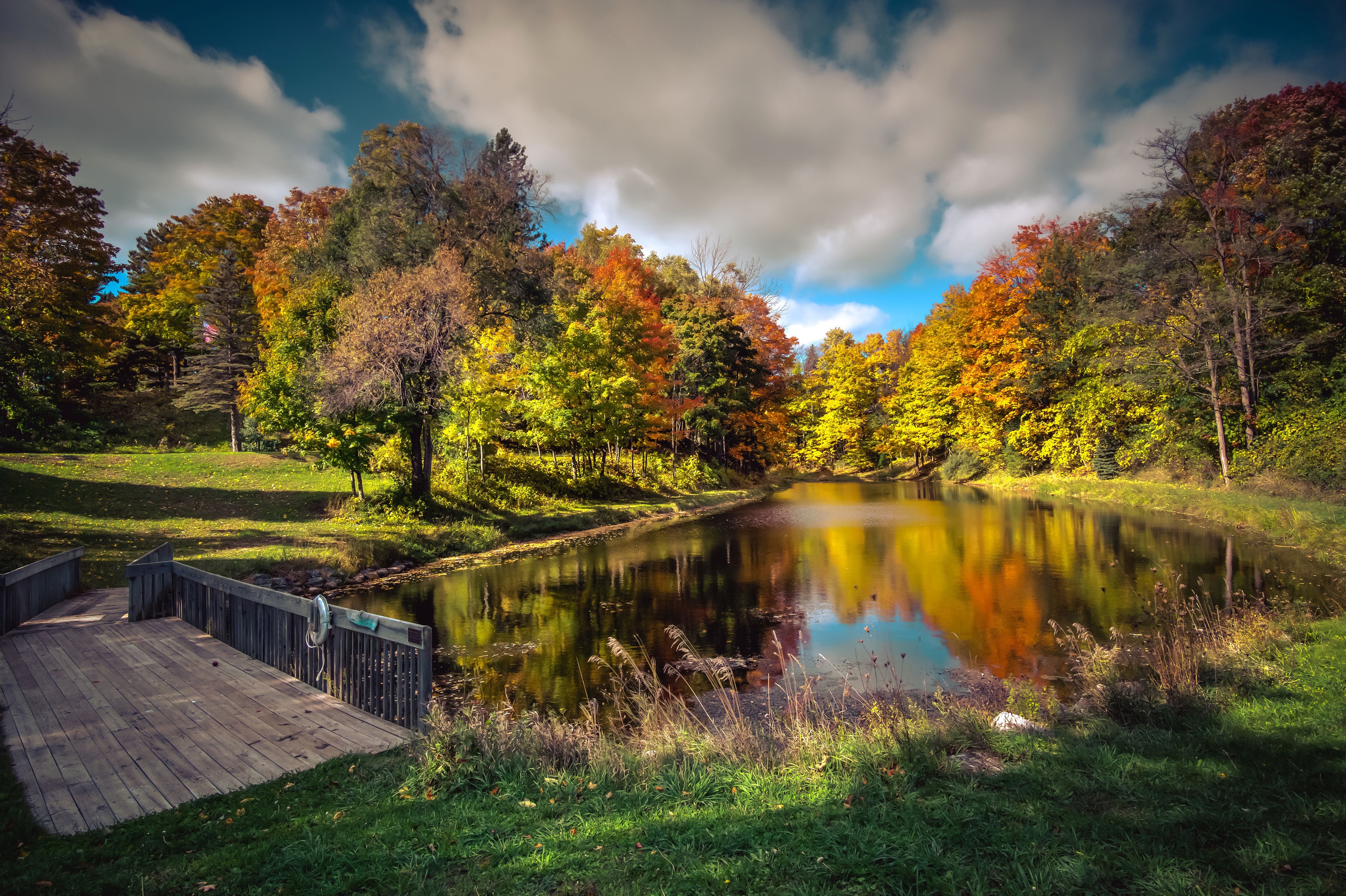 Wooden bridge overlooking a lake with autumn trees in Northport, Michigan HD Wallpaper
