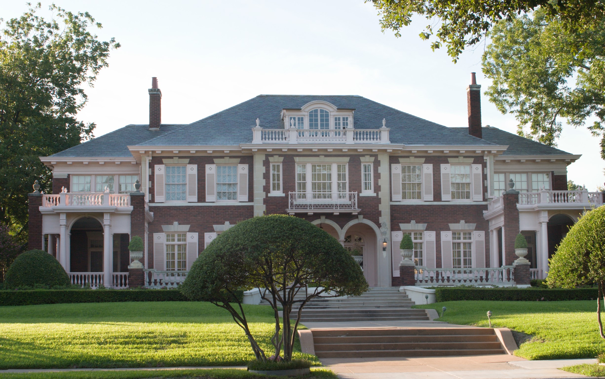 Large brick mansion with manicured lawn and trees HD Wallpaper