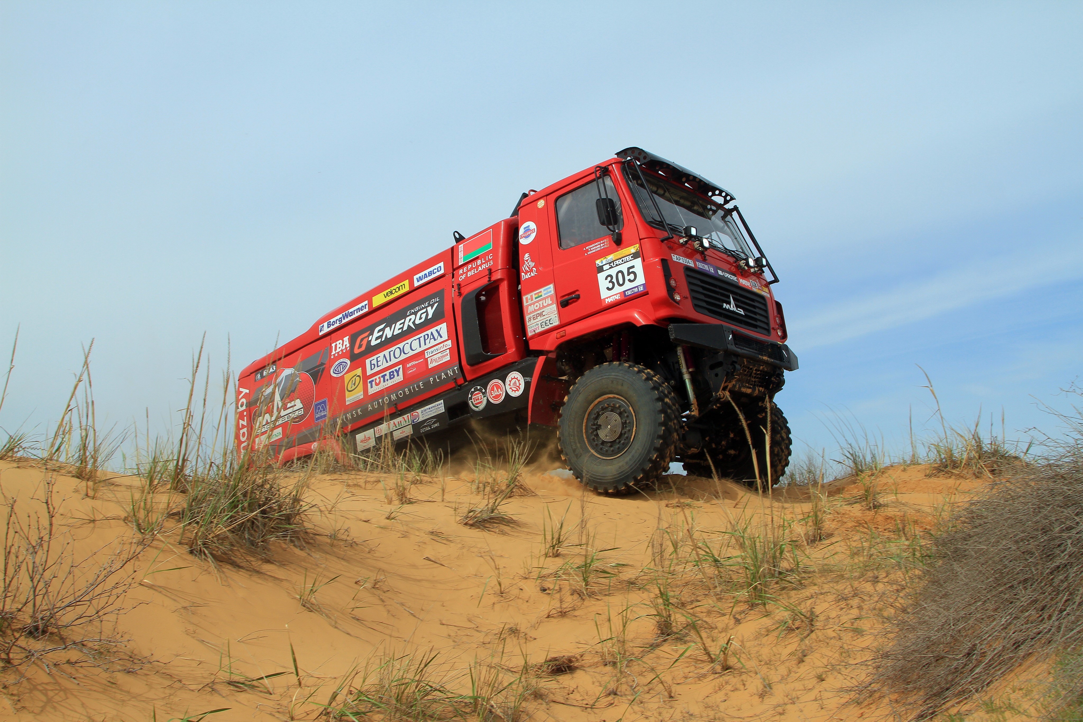 Red MAZ-5309RR rally truck driving on sand dunes HD Wallpaper